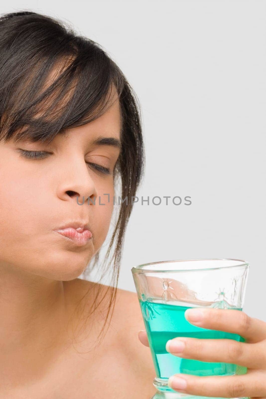 Close-up of a young woman gargling
