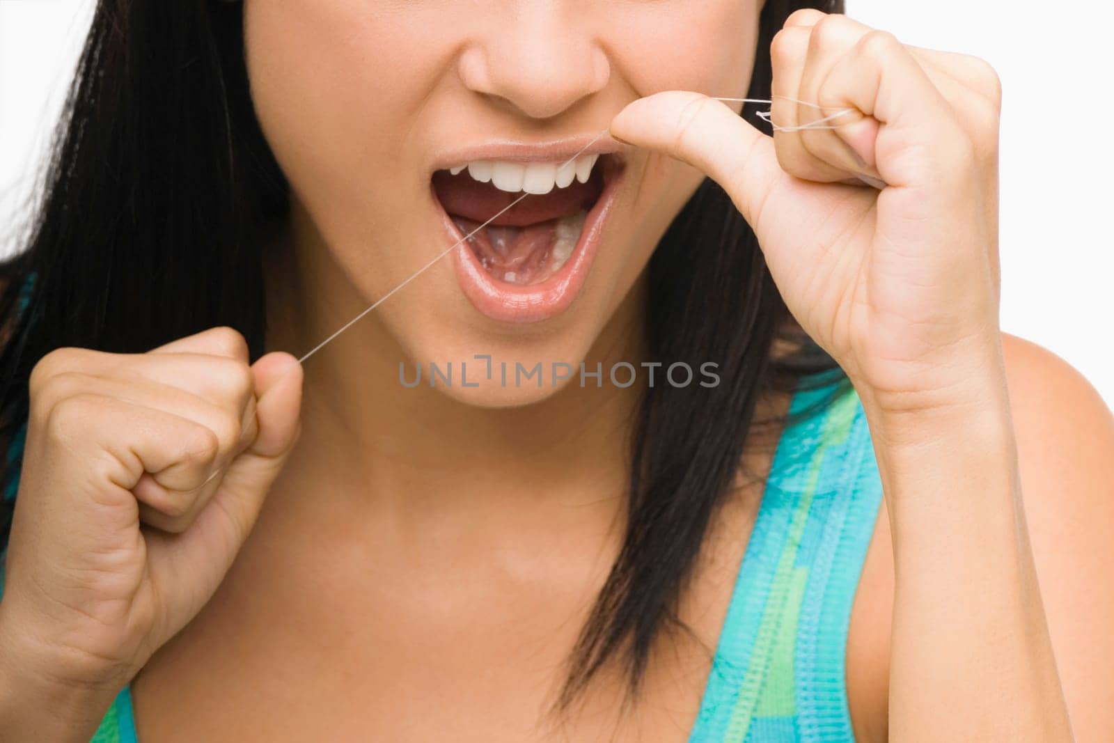 Close-up of a young woman flossing her teeth