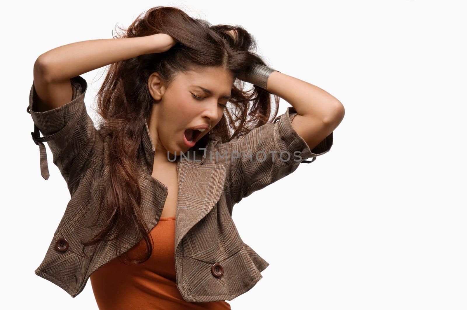 Close-up of a young woman yawning and her hands in her hair