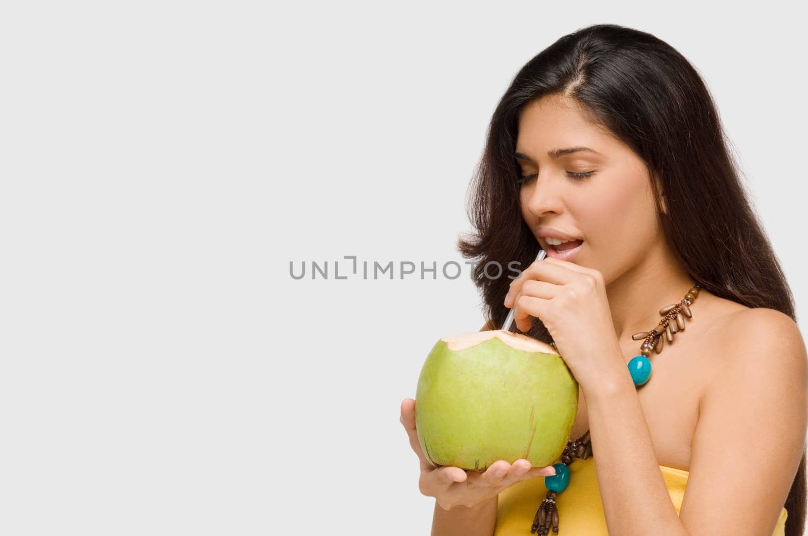 Close-up of a young woman drinking coconut milk