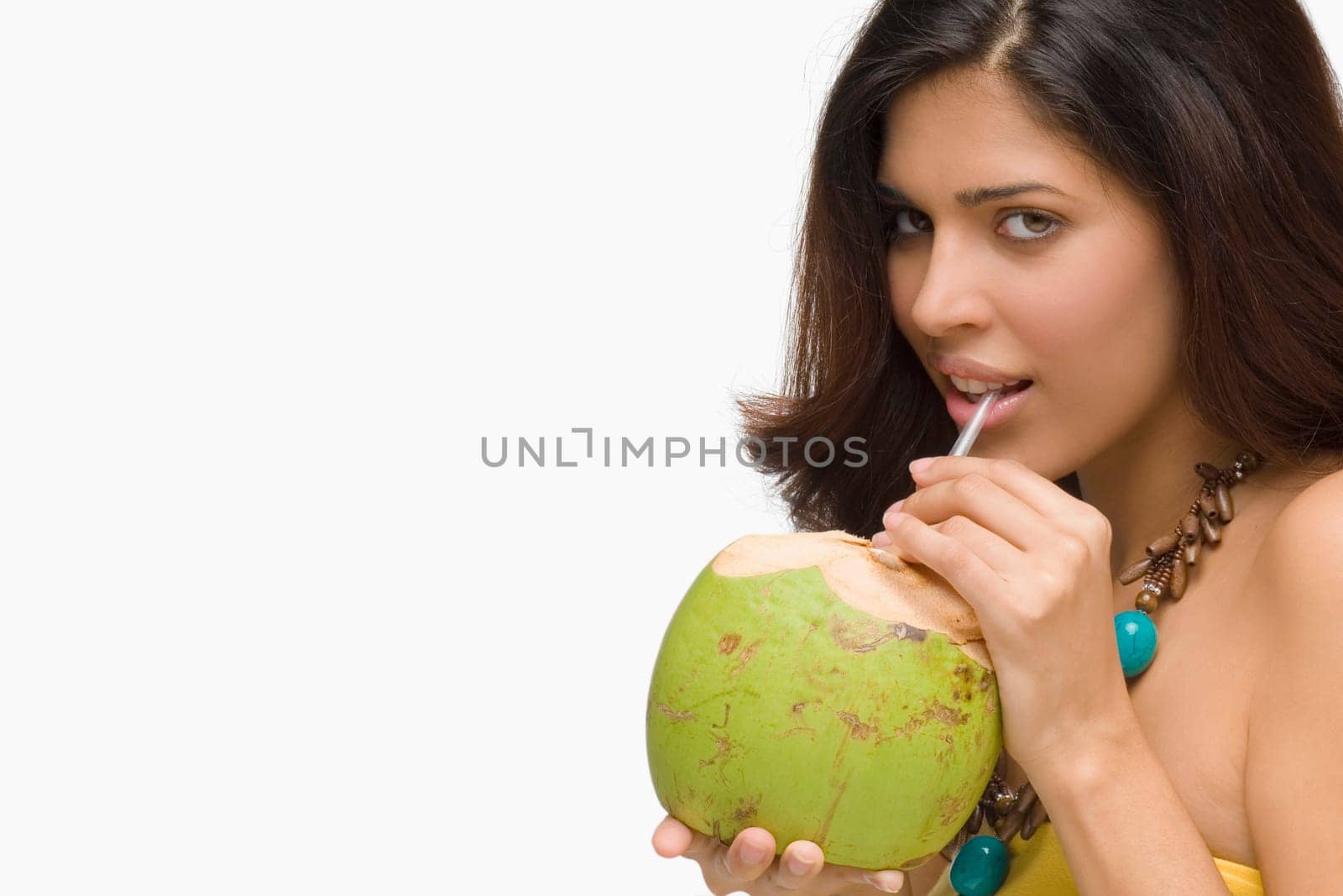 Portrait of a young woman drinking coconut milk