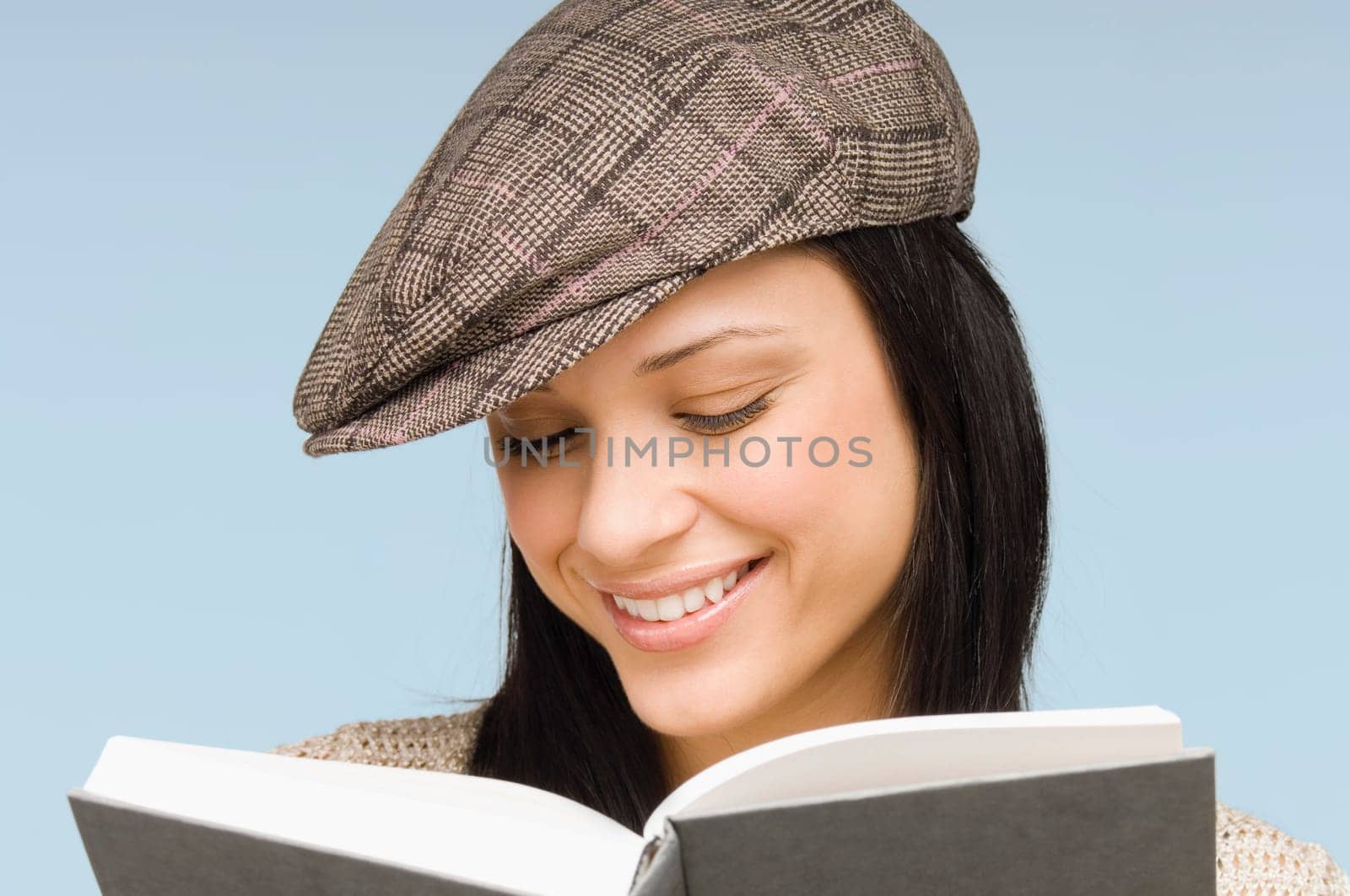 Close-up of a young woman reading a book and smiling