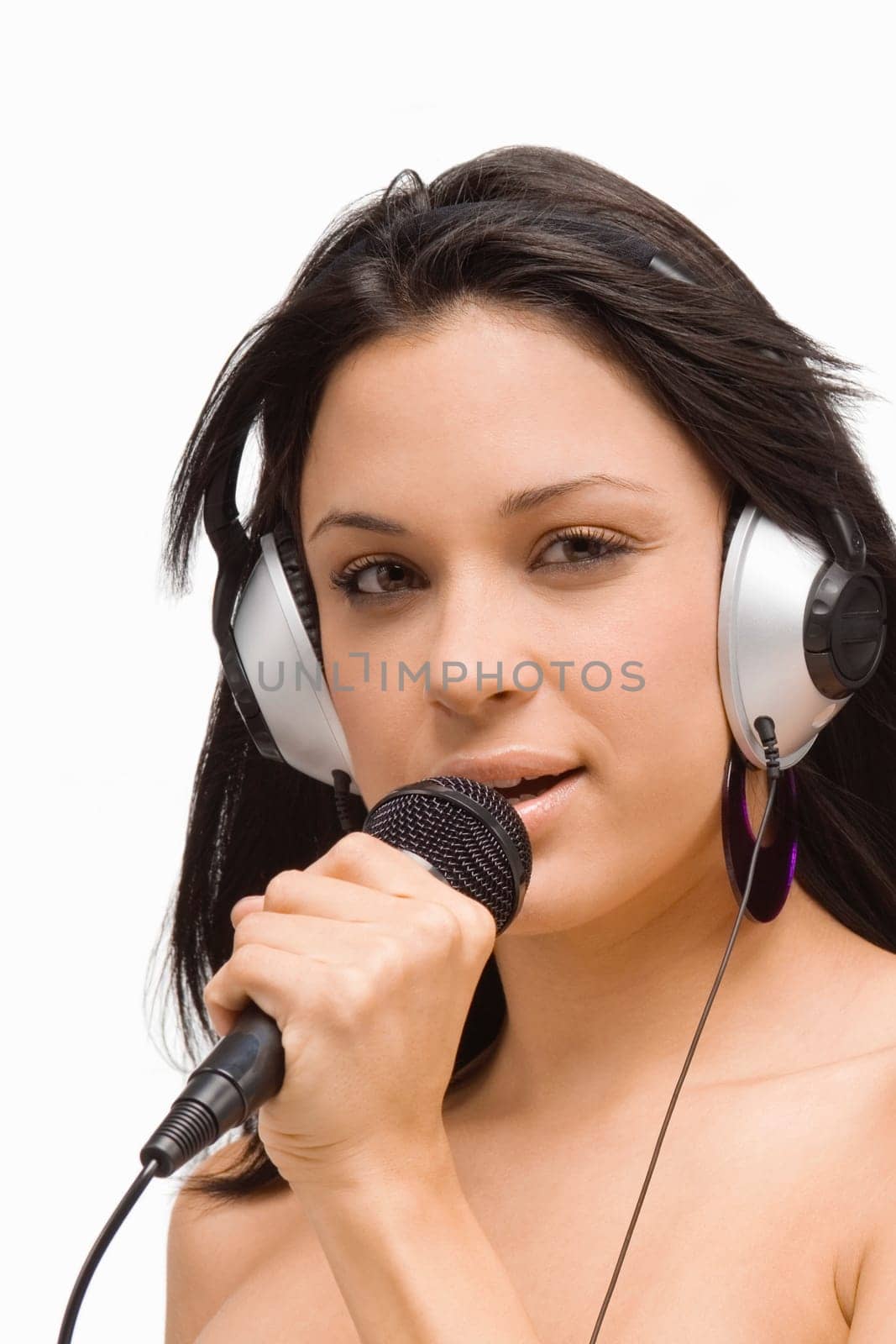 Portrait of a young woman singing into a microphone