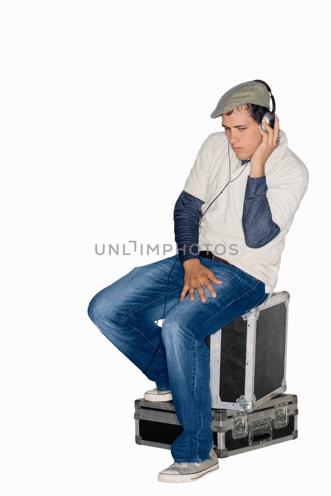 Young man sitting on trunks and listening to music