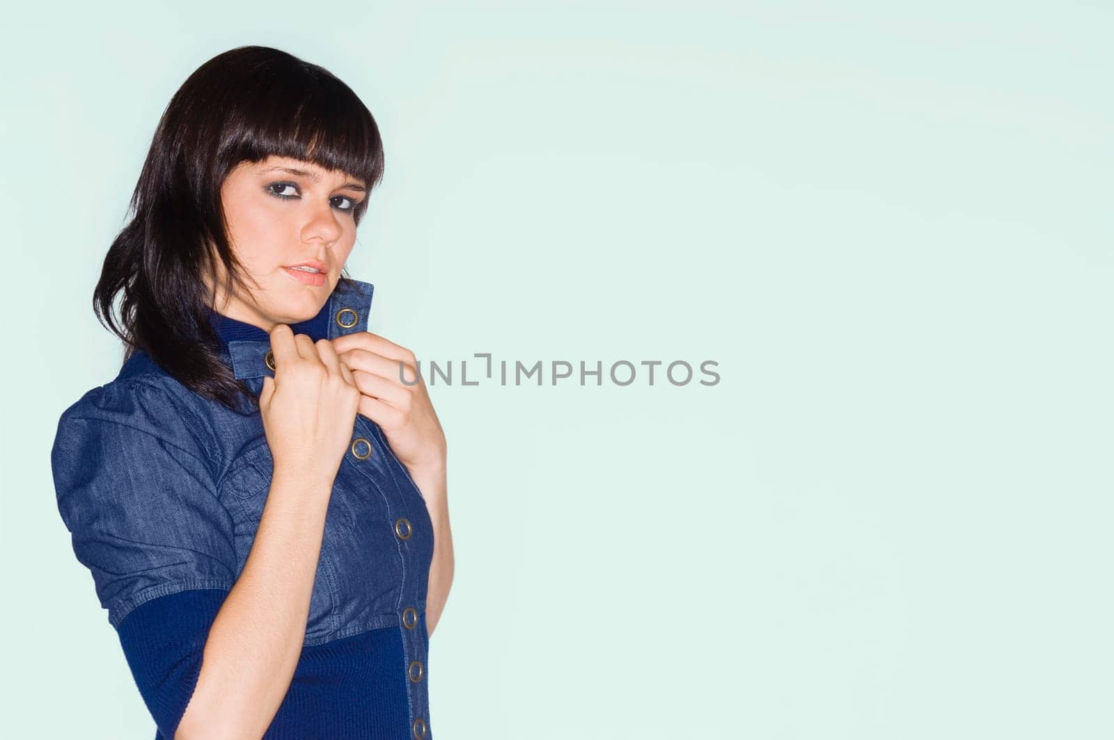 Portrait of a young woman adjusting her collar