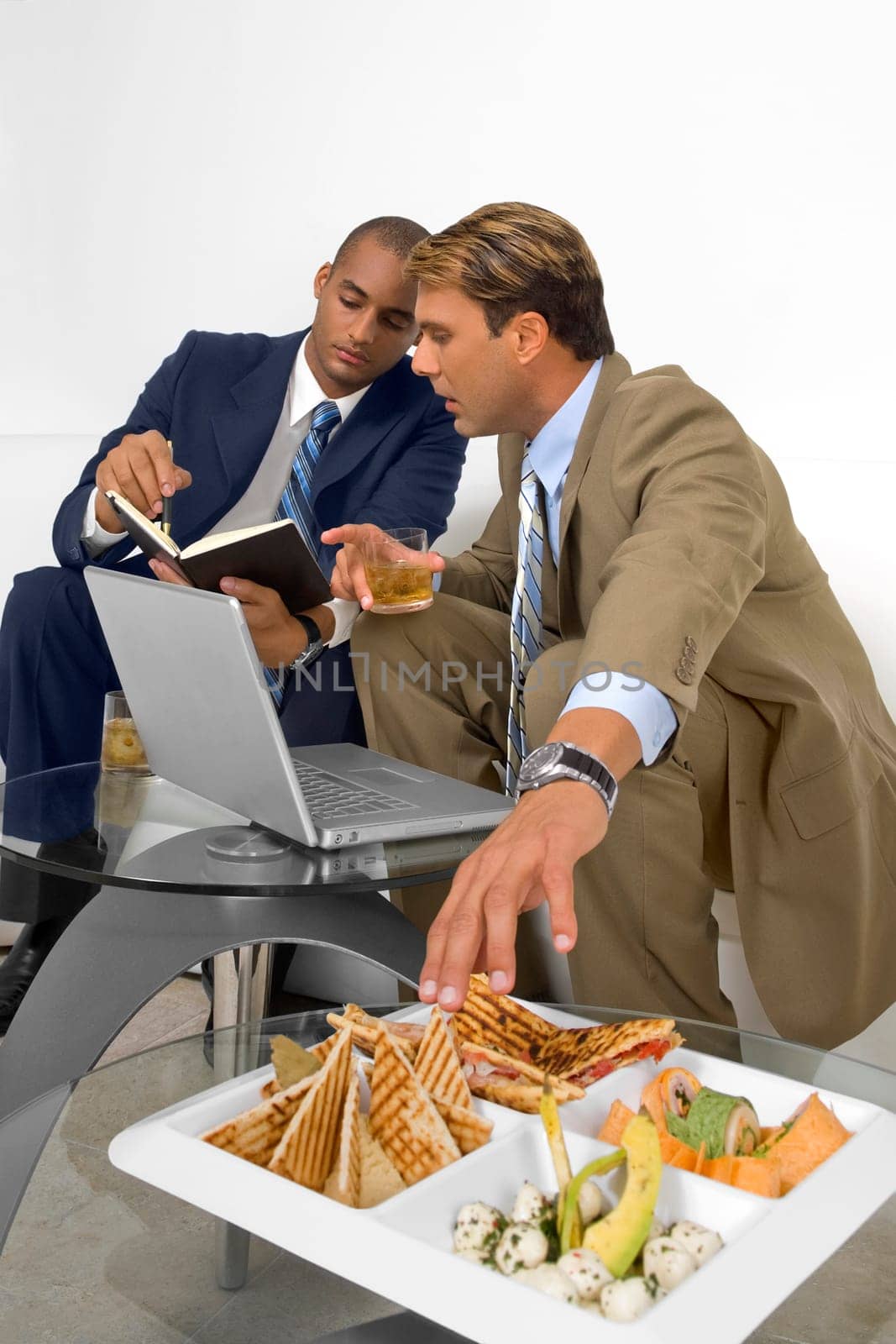 Two businessmen sitting on a couch and having a discussion
