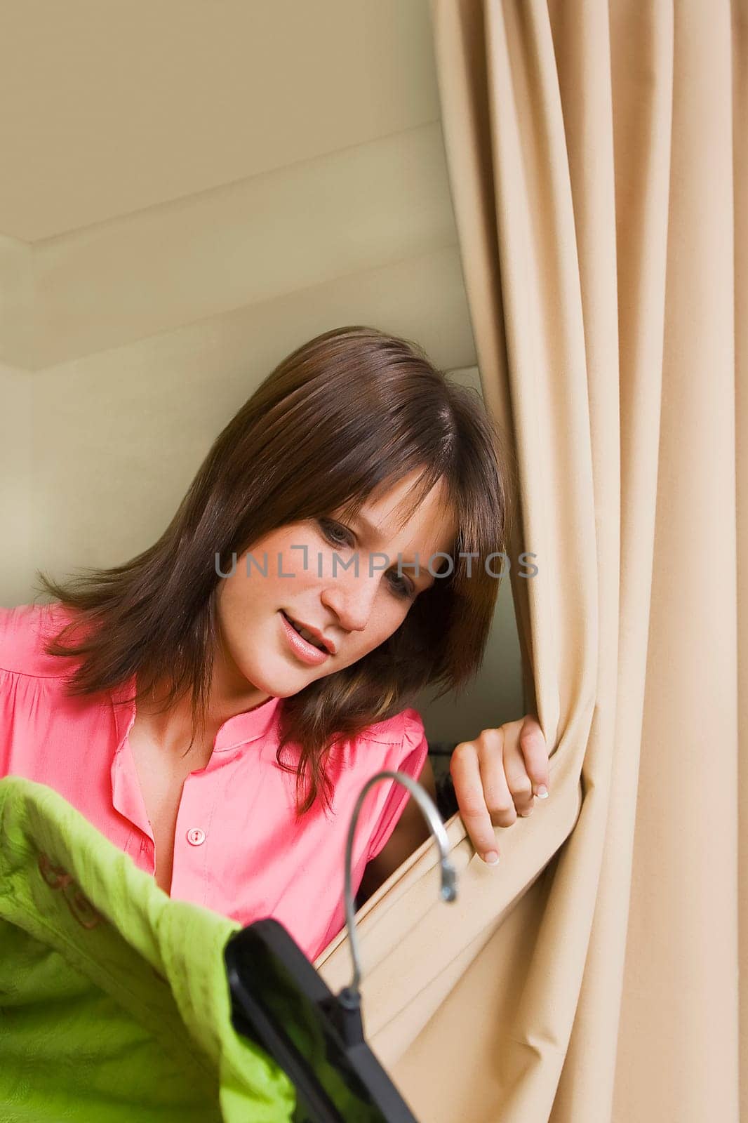 Young woman looking at a dress in a fitting room