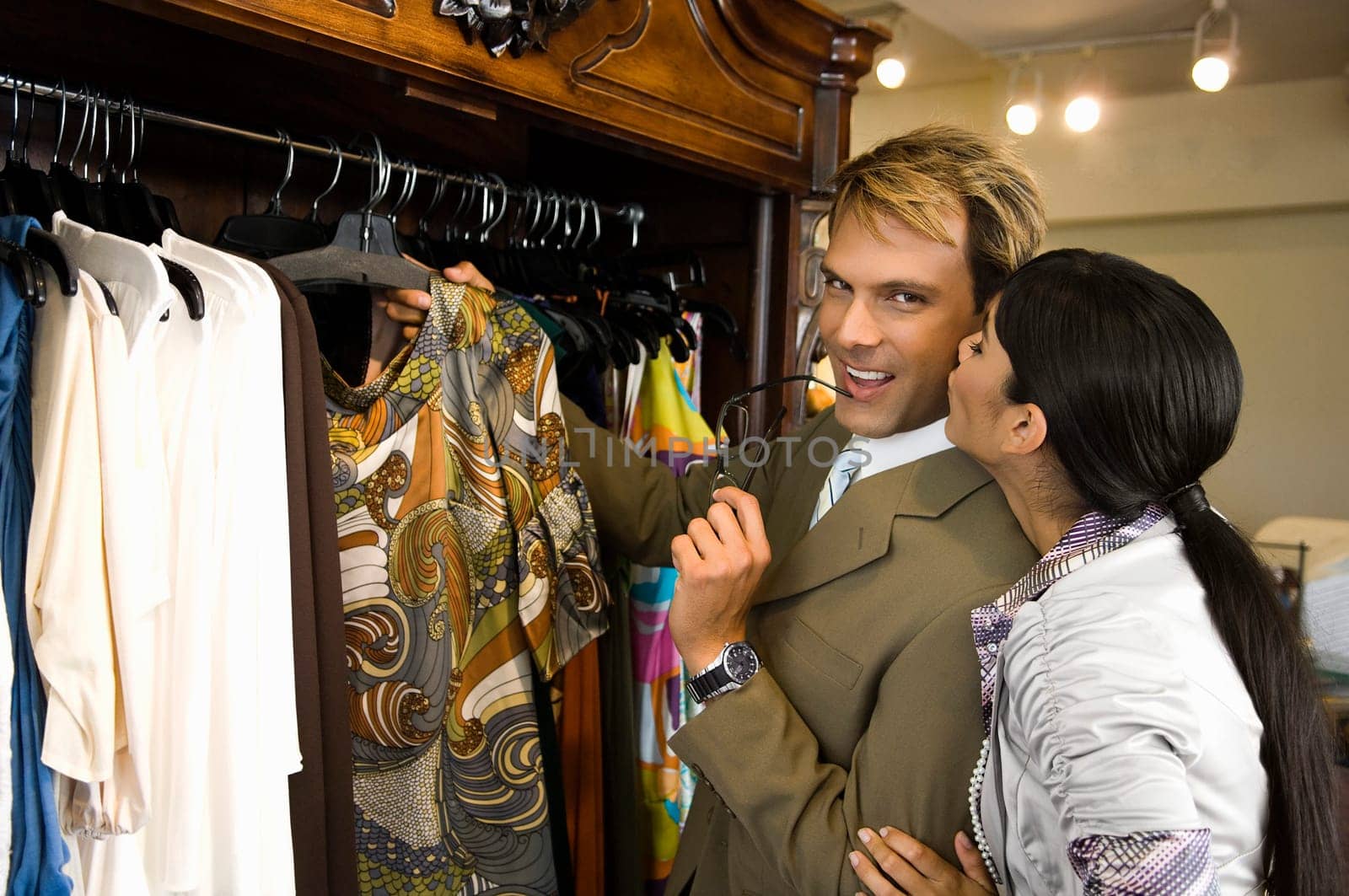 Young woman kissing a mid adult man in a clothing store