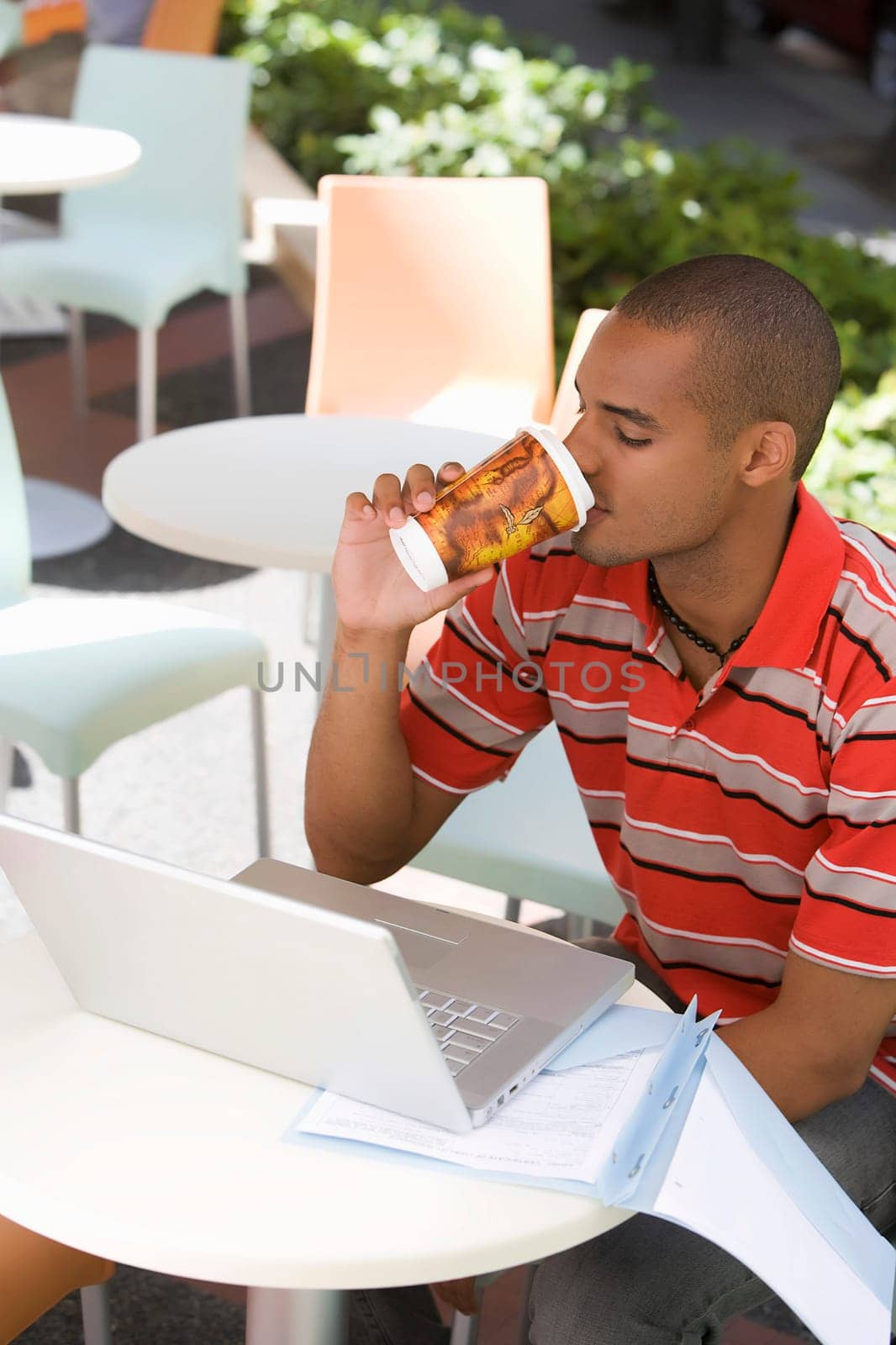 Young man sitting at a cafe and drinking coffee