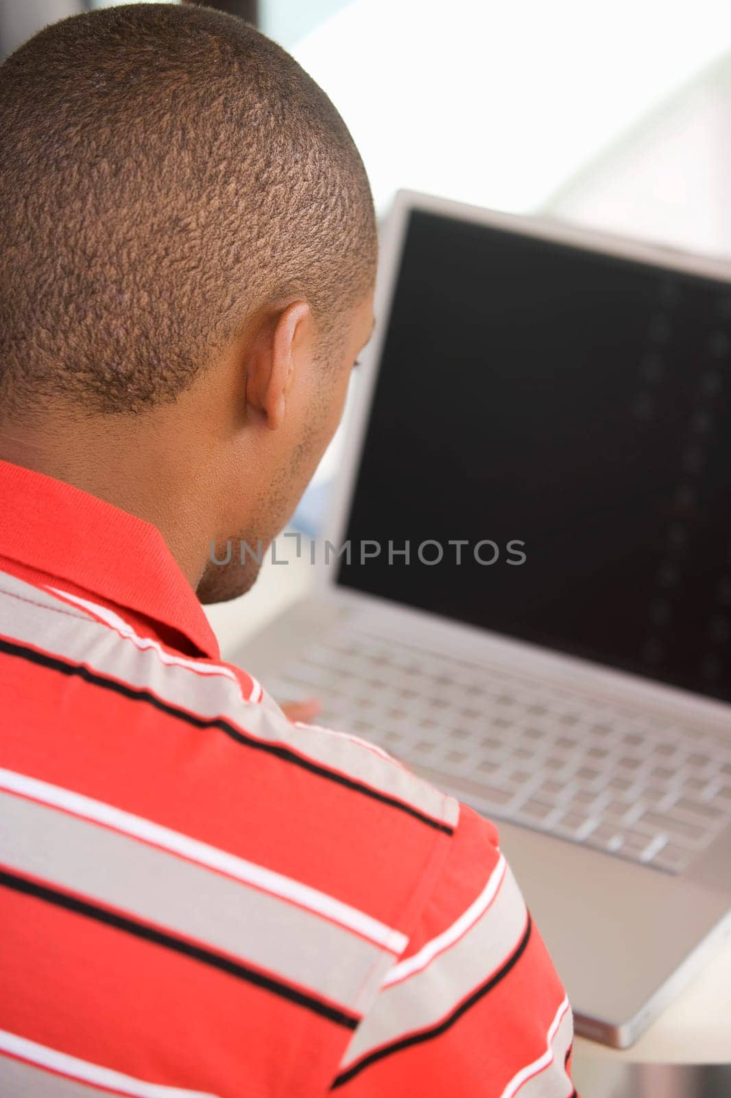Rear view of a young man using a laptop