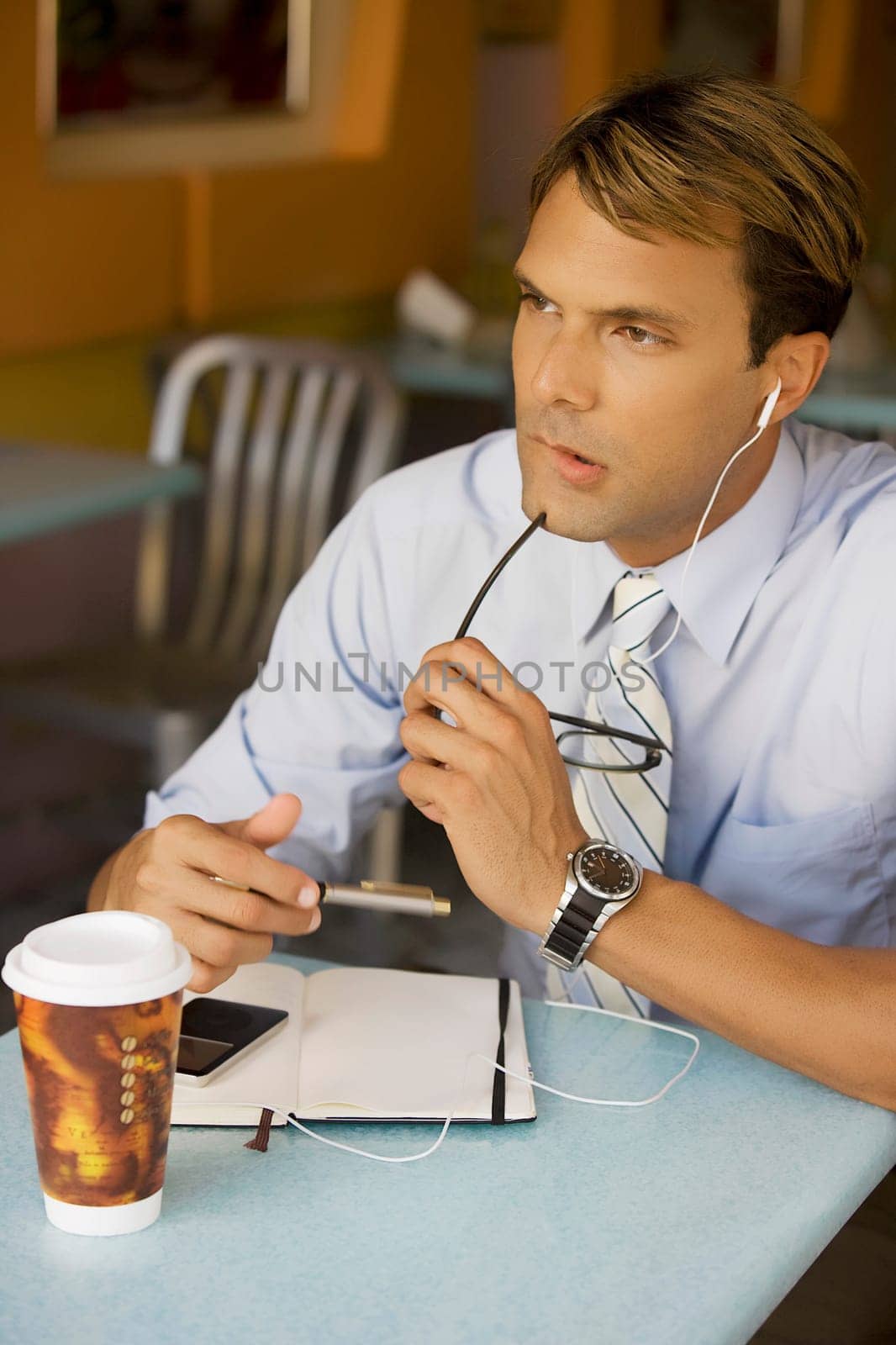 Businessman listening to an MP3 player and thinking