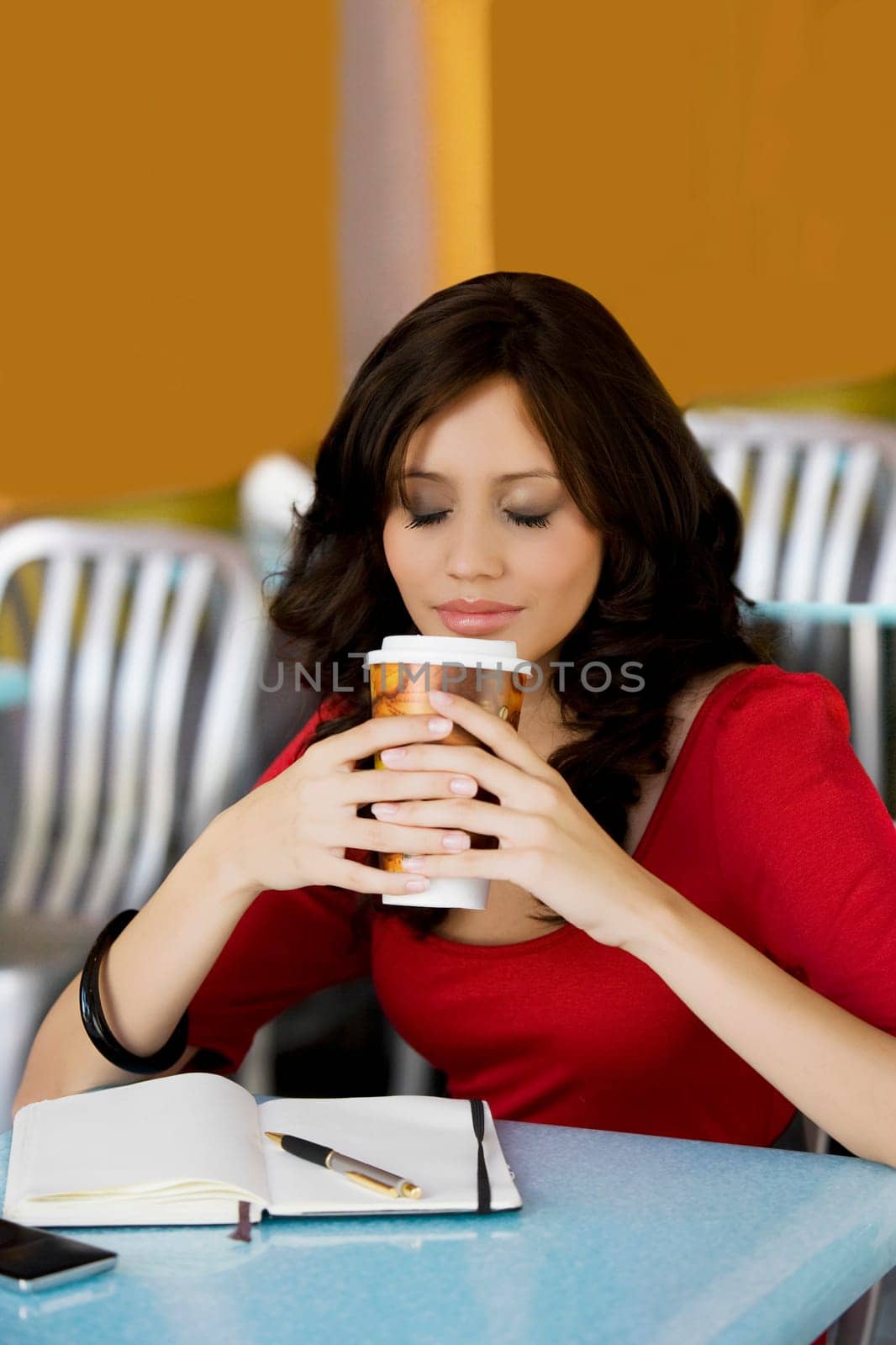 Young woman holding a cup of cold drink in a cafe