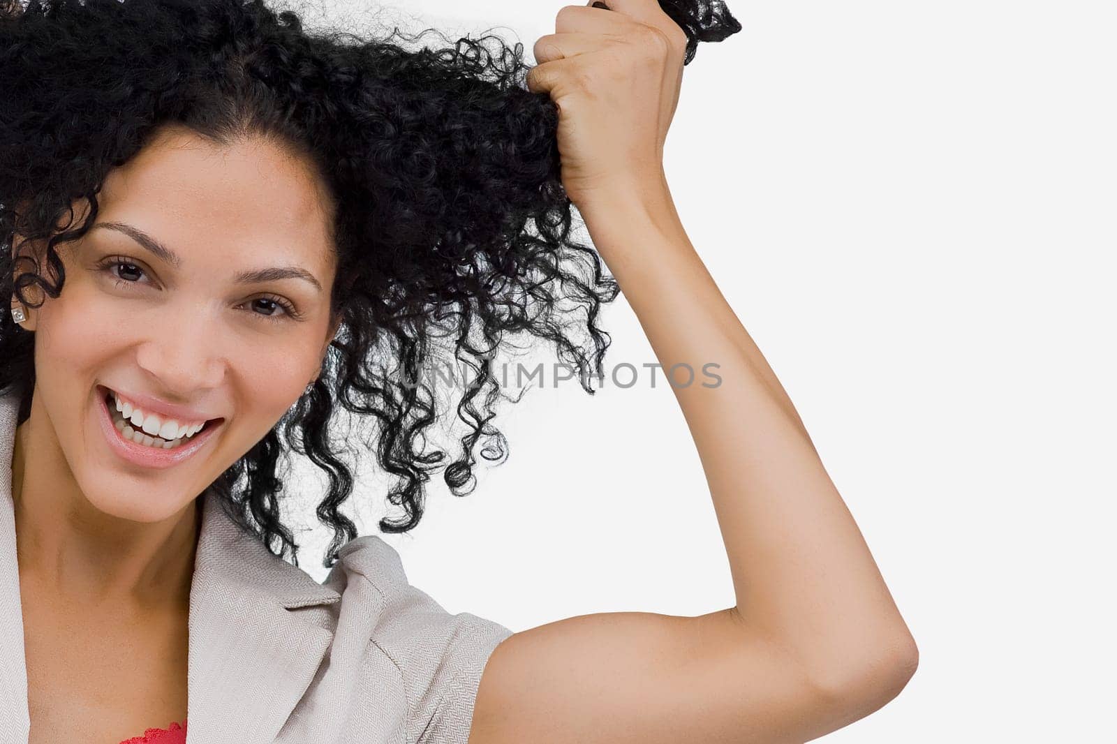Portrait of a young woman holding her hair and smiling