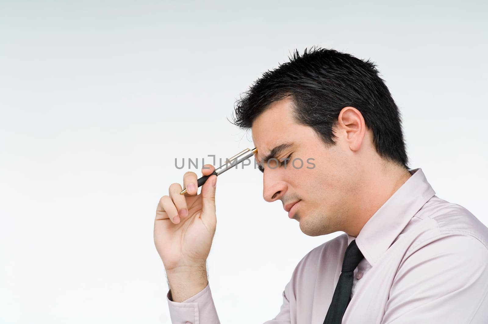 Close-up of a businessman holding a pen and thinking