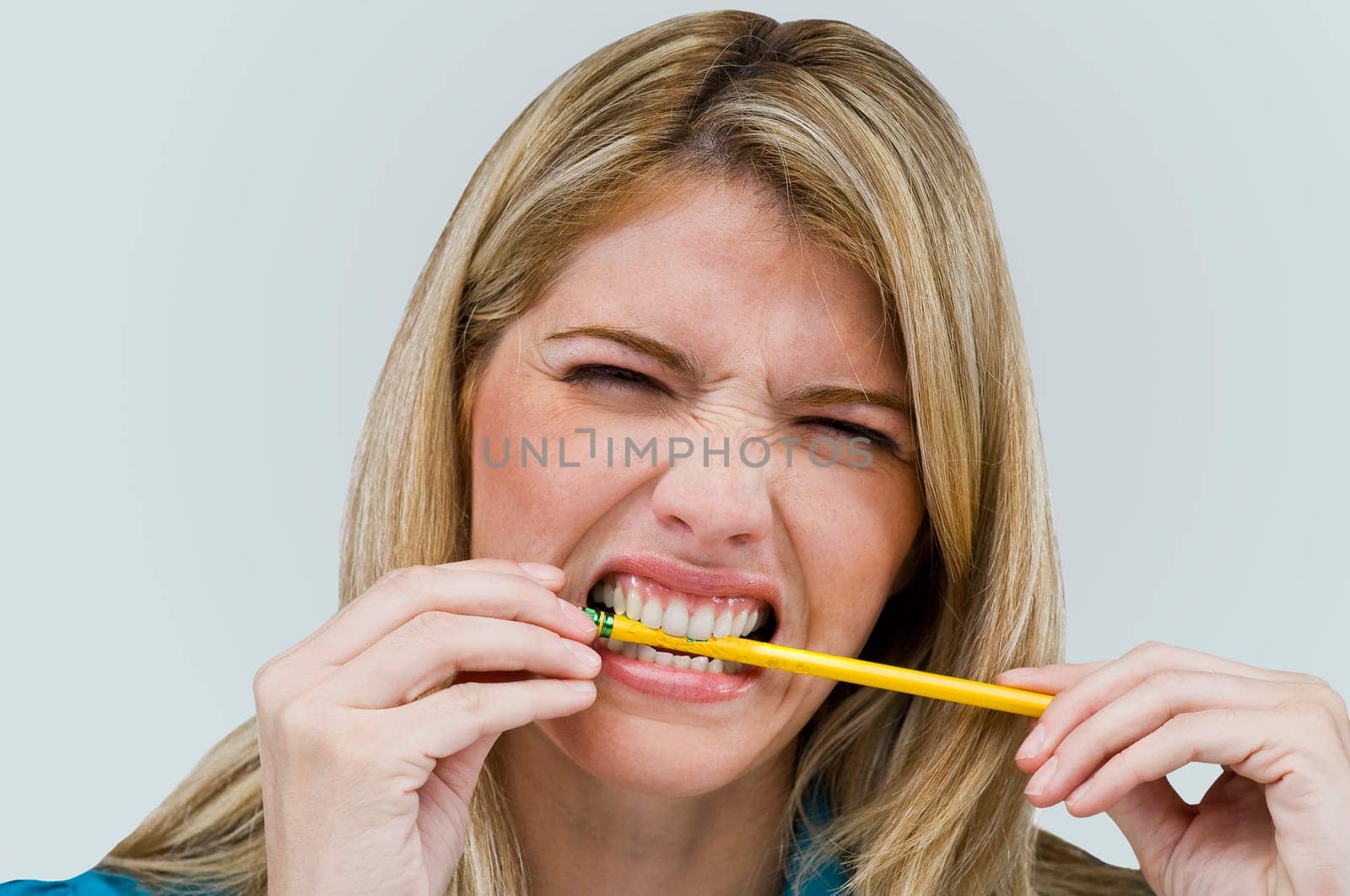 Close-up of a young woman biting a pencil