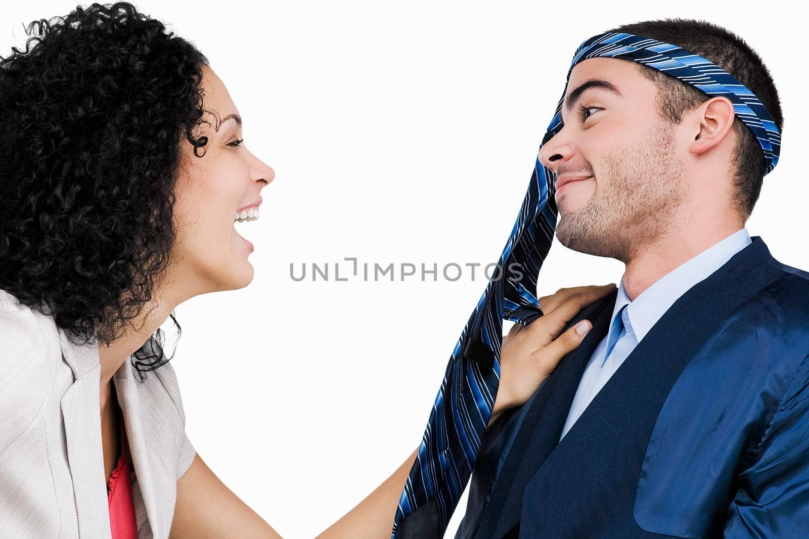 Close-up of a businessman wearing a tie on his head with a businesswoman laughing at him