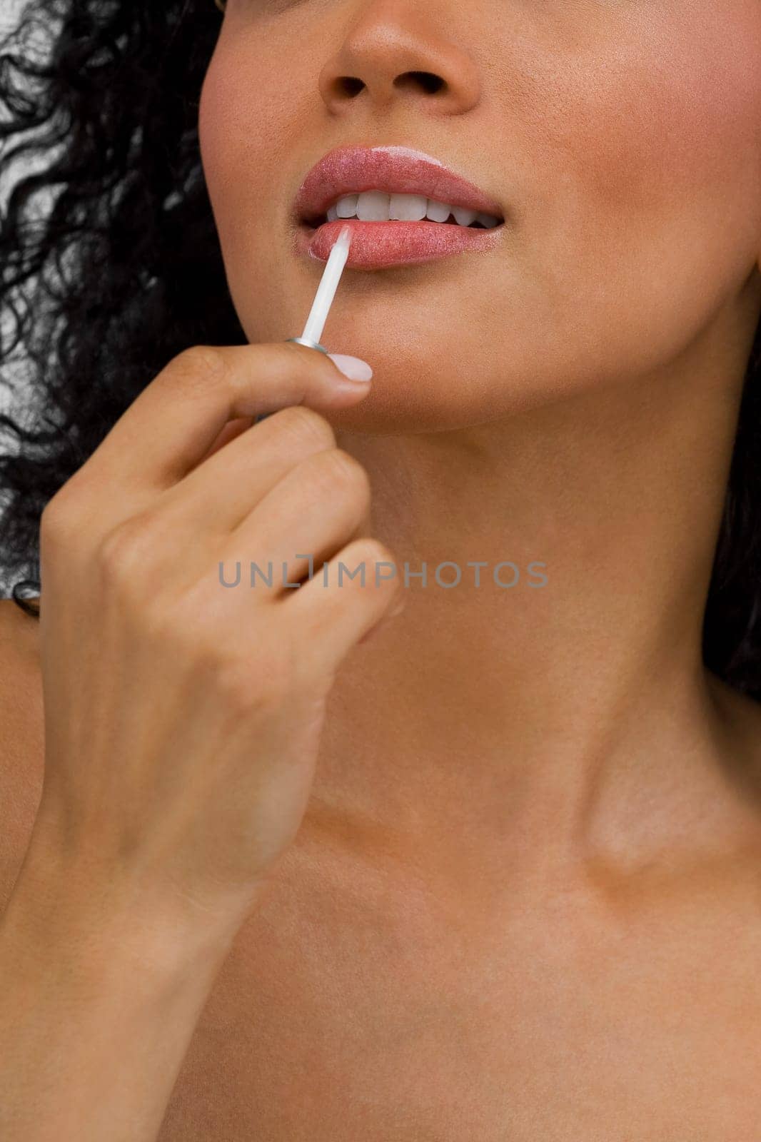 Close-up of a young woman applying lipstick