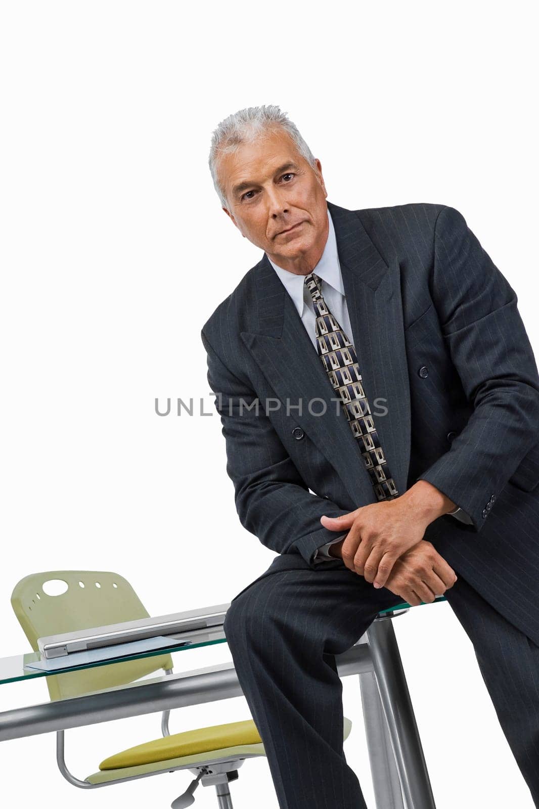 Portrait of a businessman sitting on a desk in an office