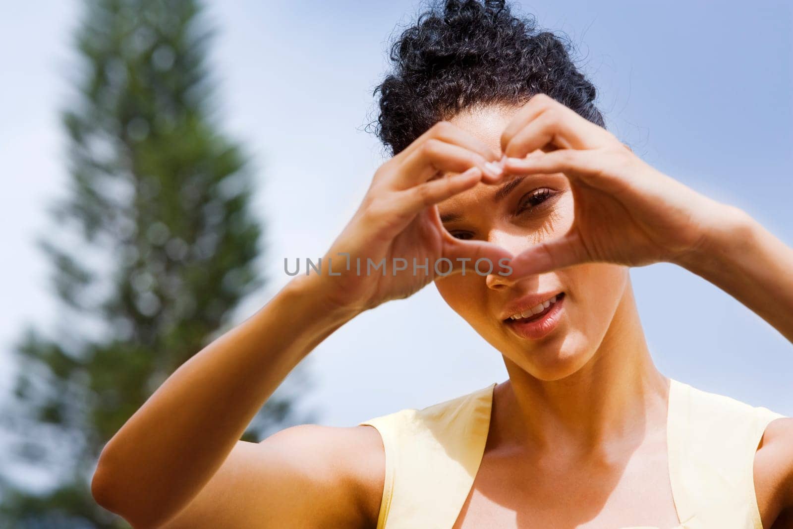 Woman making heart shape with her hands in front of her face