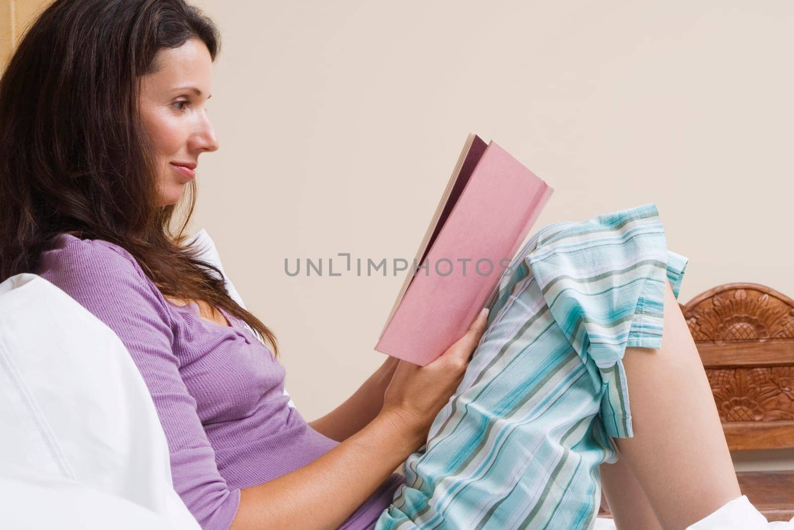 Close-up of a mid adult woman reading a book and smirking