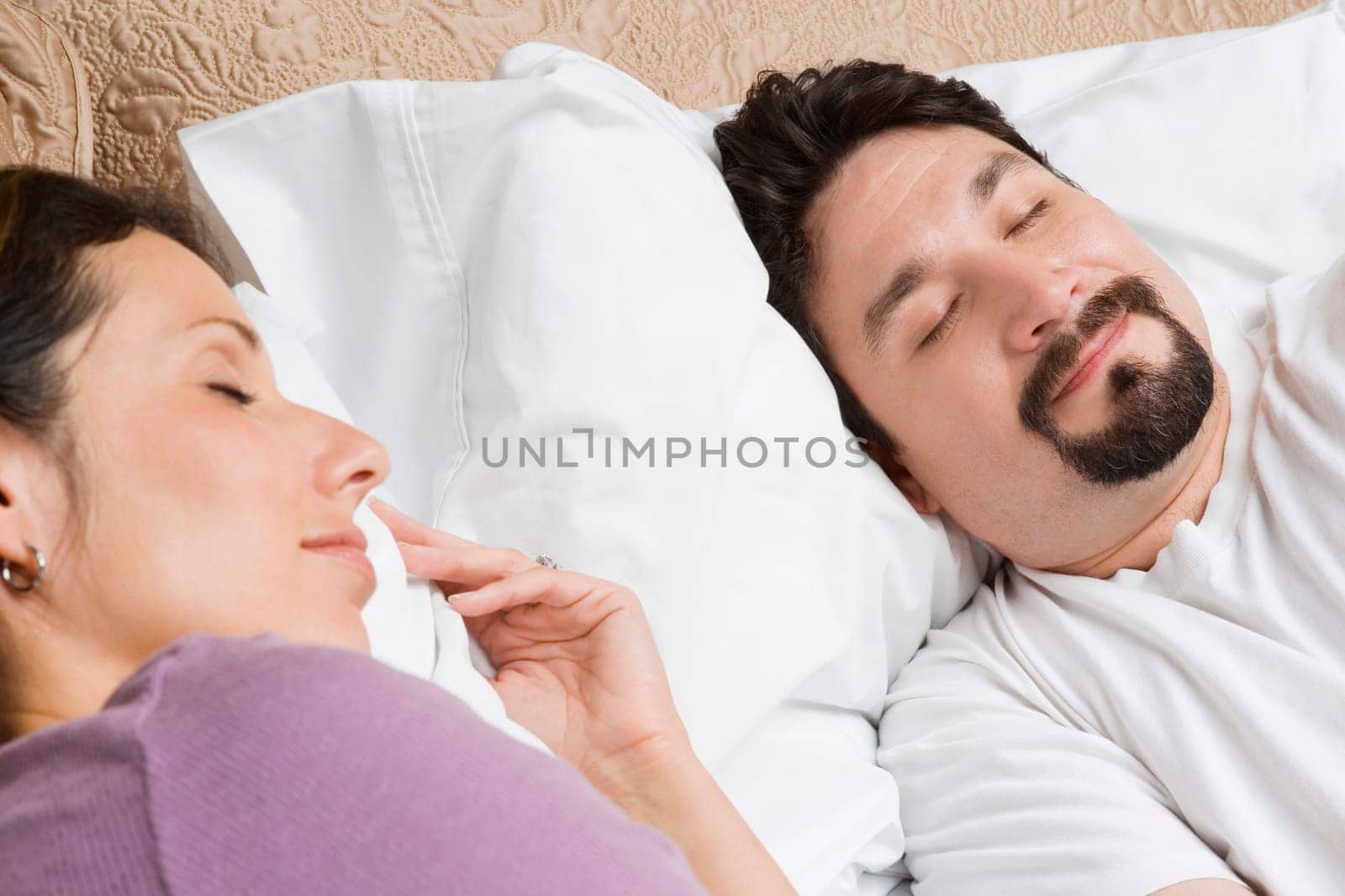Close-up of a mid adult couple sleeping on the bed