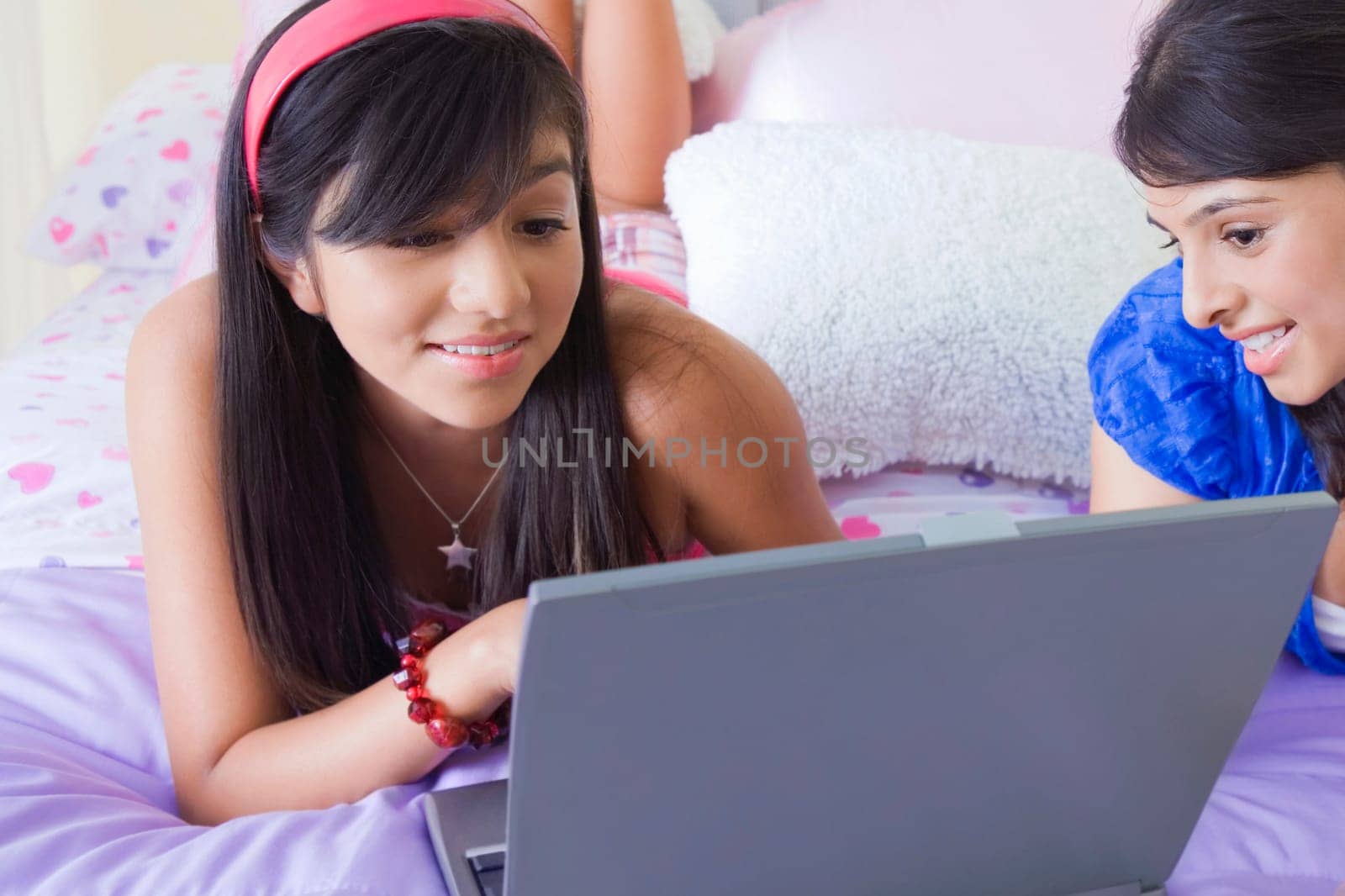 Teenage girl and a young woman looking at a laptop and smiling