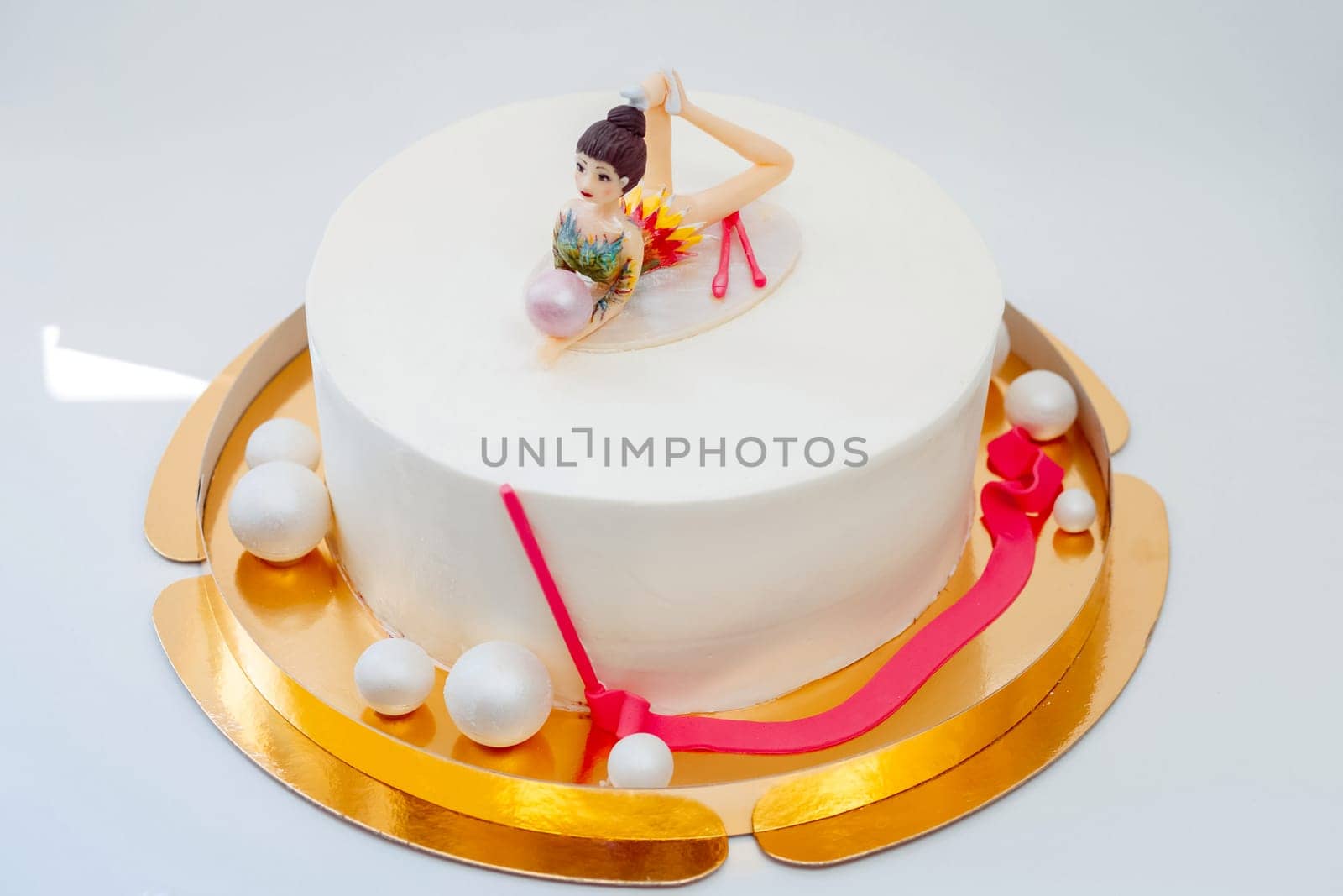 White cake with a gymnast's figure. Cake for the athlete.