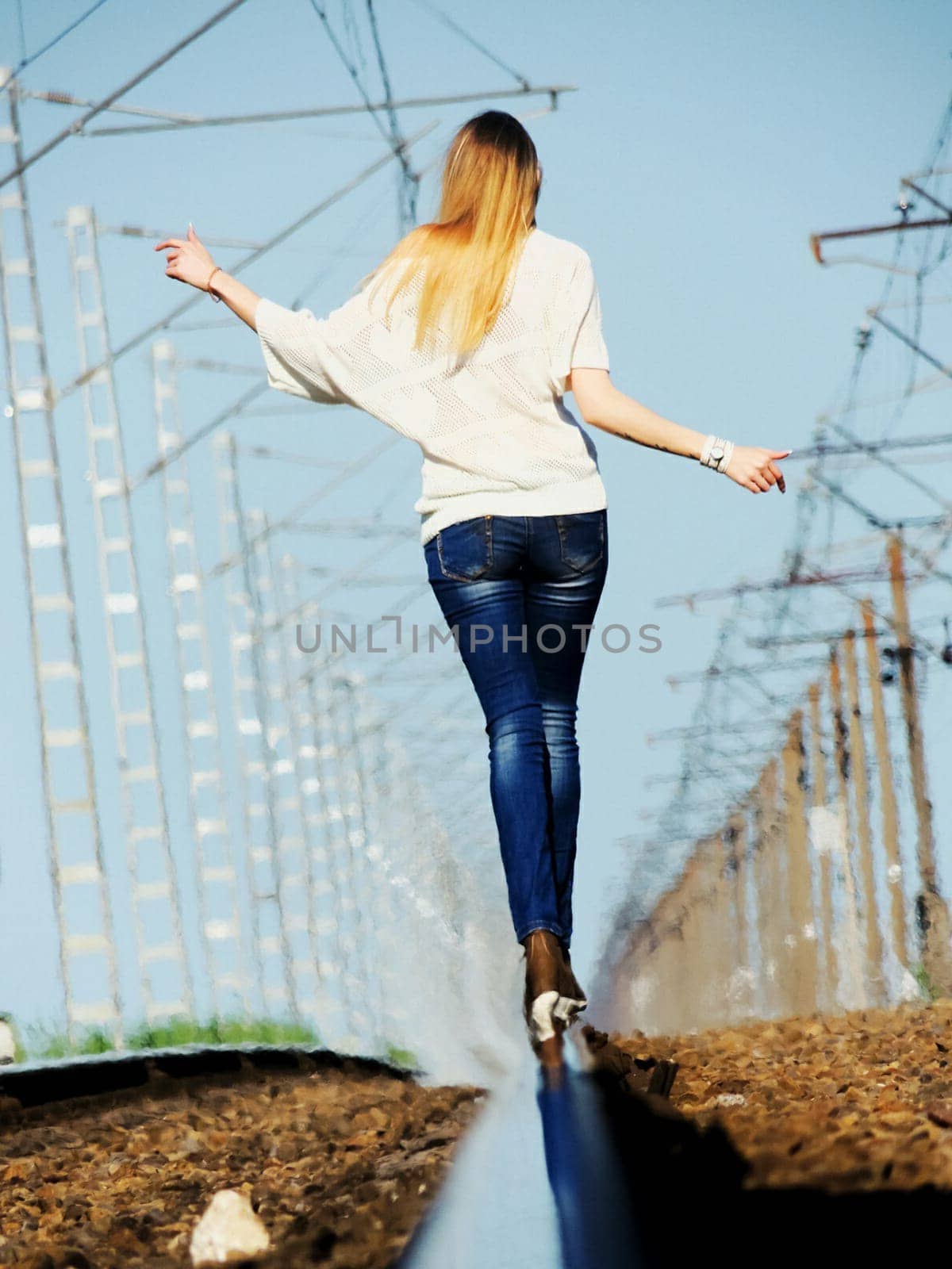 A girl walks on the rails of the railway. Walking on the tracks.