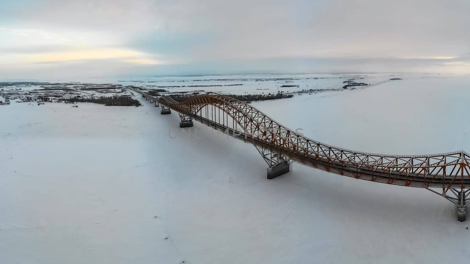 A bridge over the river in the ice in winter. The oil-yugan bridge over the region.