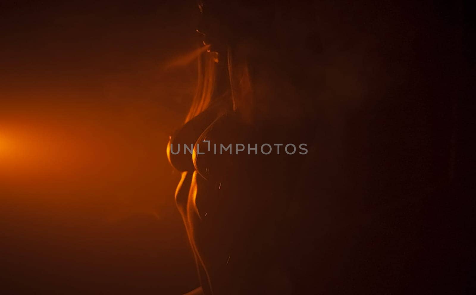 Nude woman in dark red counter light. in dark red counter light.