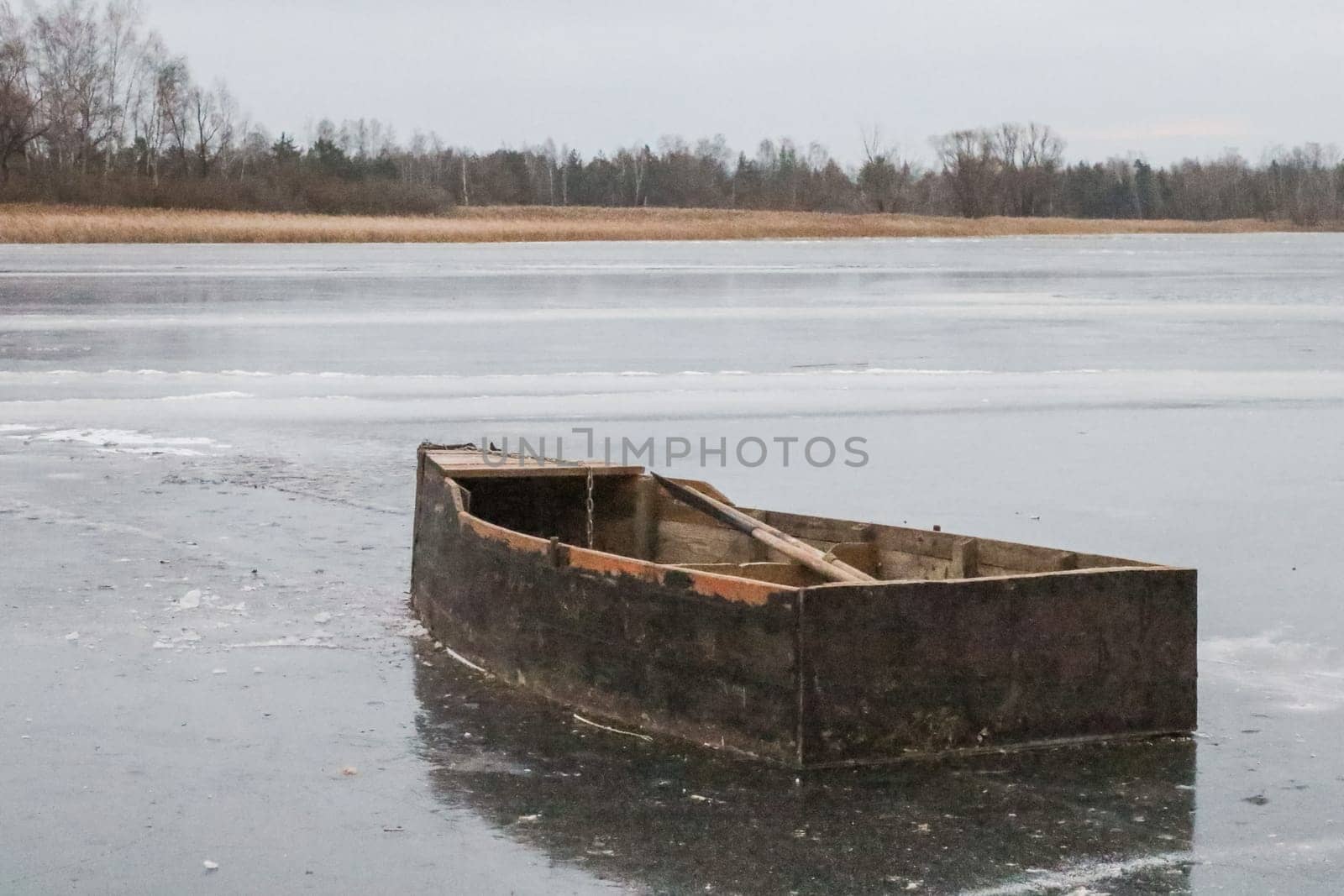 An old wooden boat on the river in the autumn.