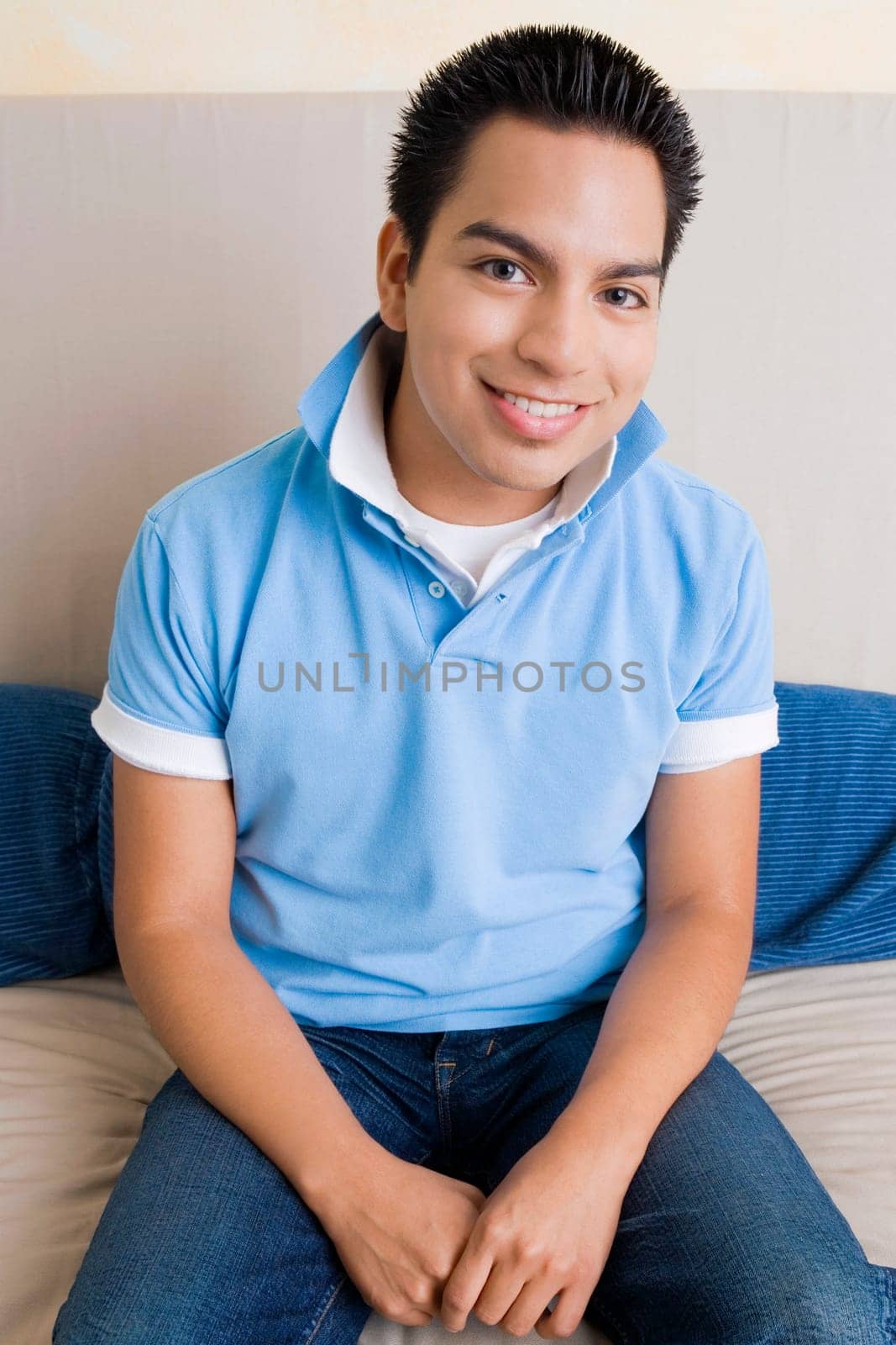 Portrait of a young man sitting on a couch and smiling