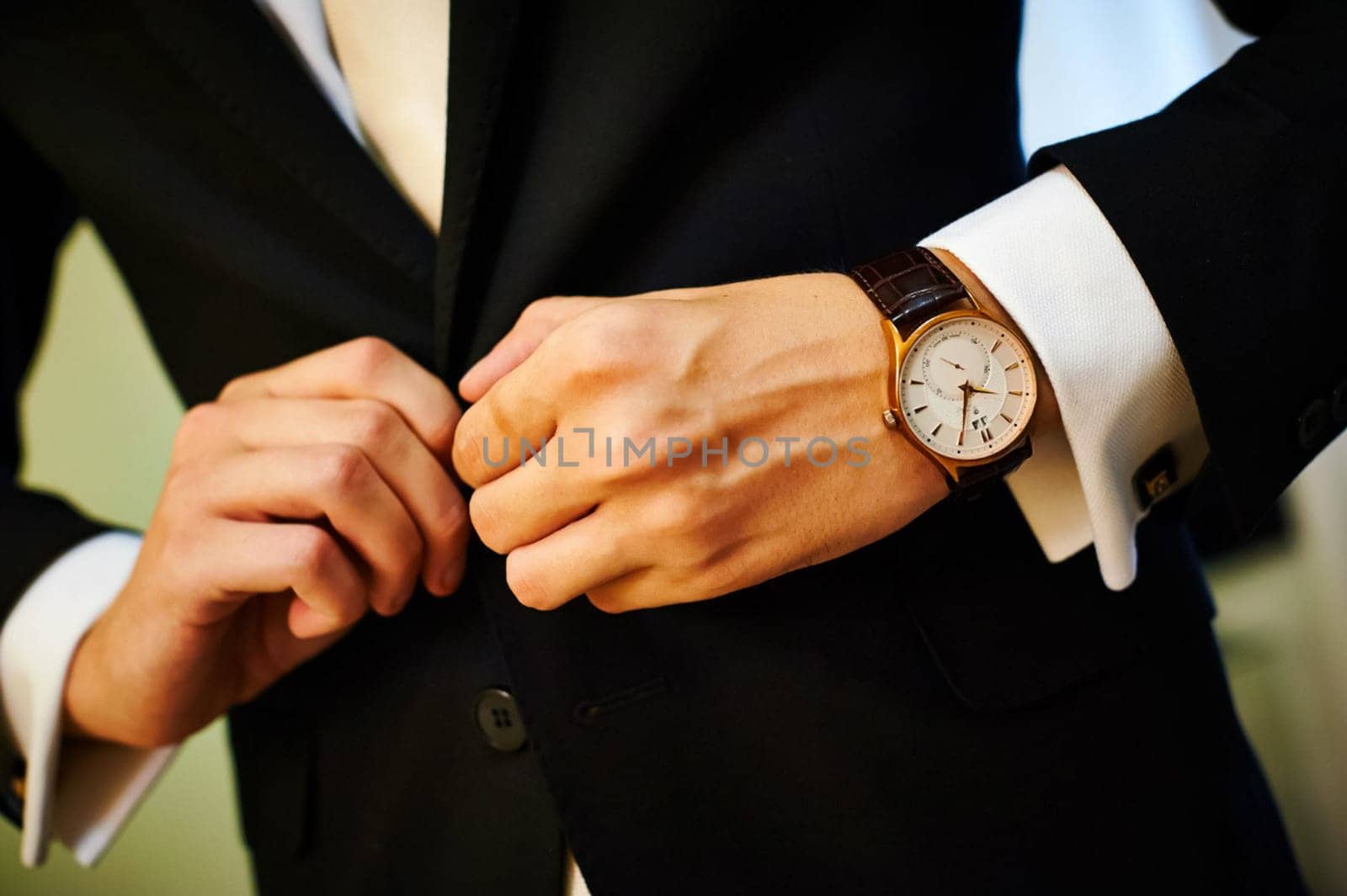 Moodina buttons on her black jacket. I have a watch on his hands.