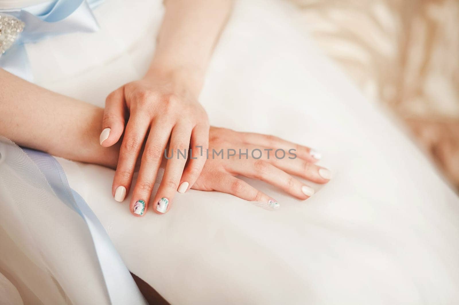 The bride sits folded her armly dress. Wedding photo.