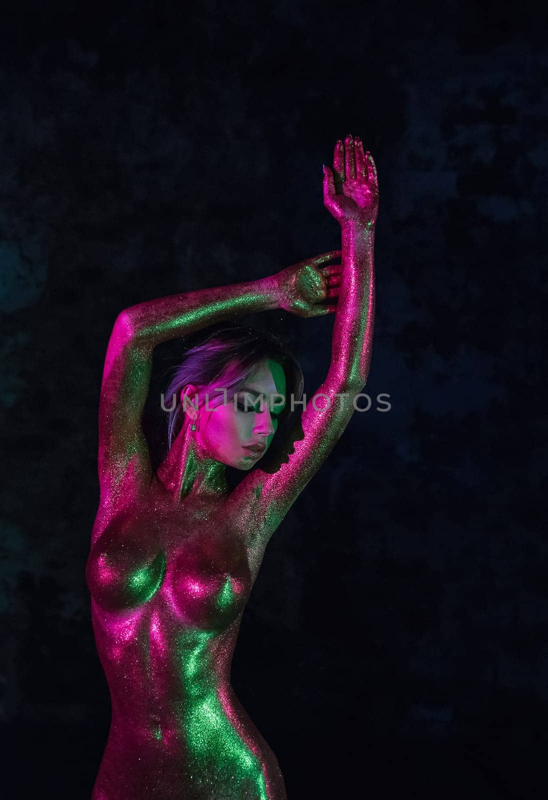 Nude woman in gold paint. Golden body art in gold paint. Golden body art