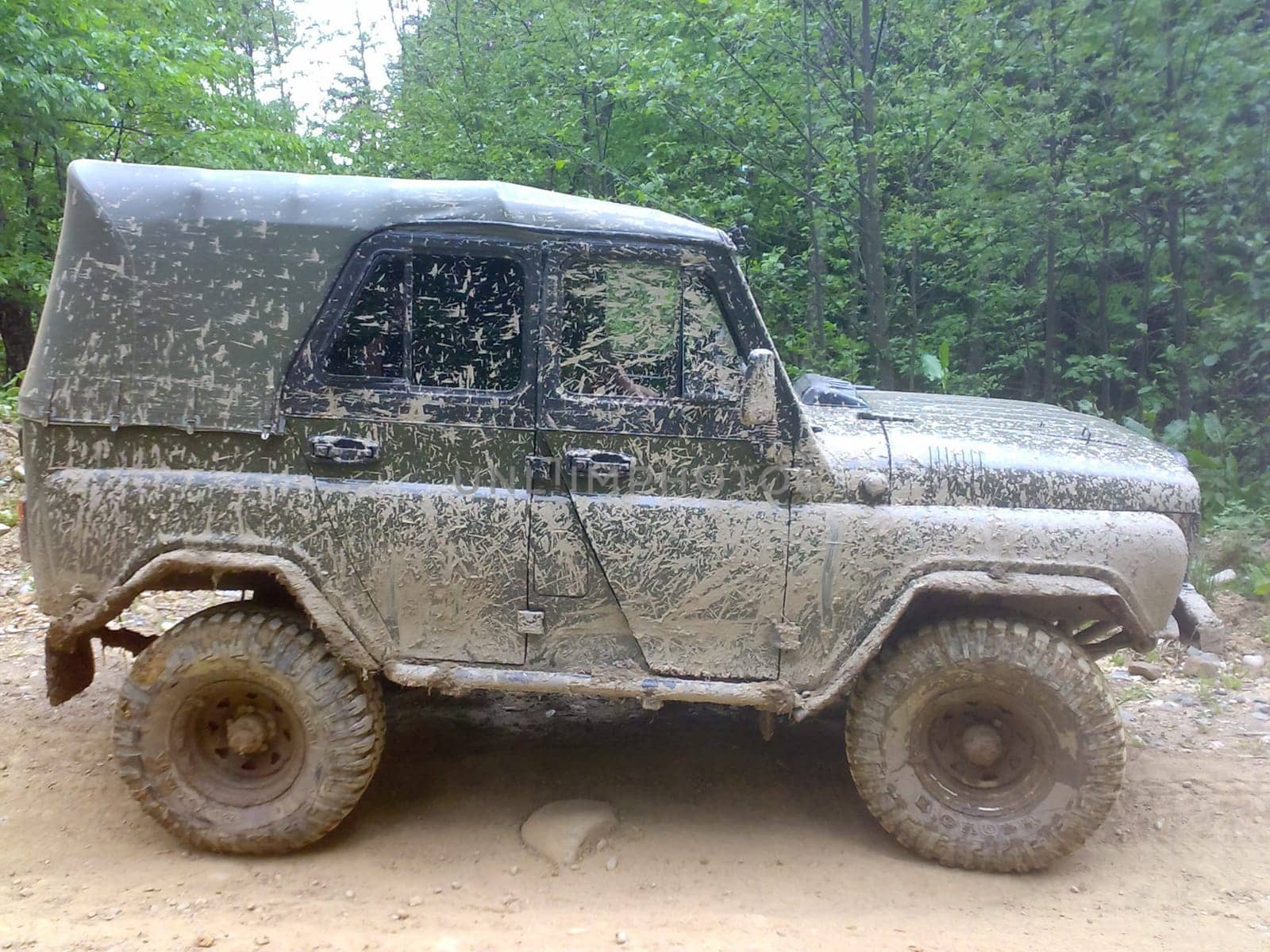 It's a very dirty car. The SUV is driving through the mud.