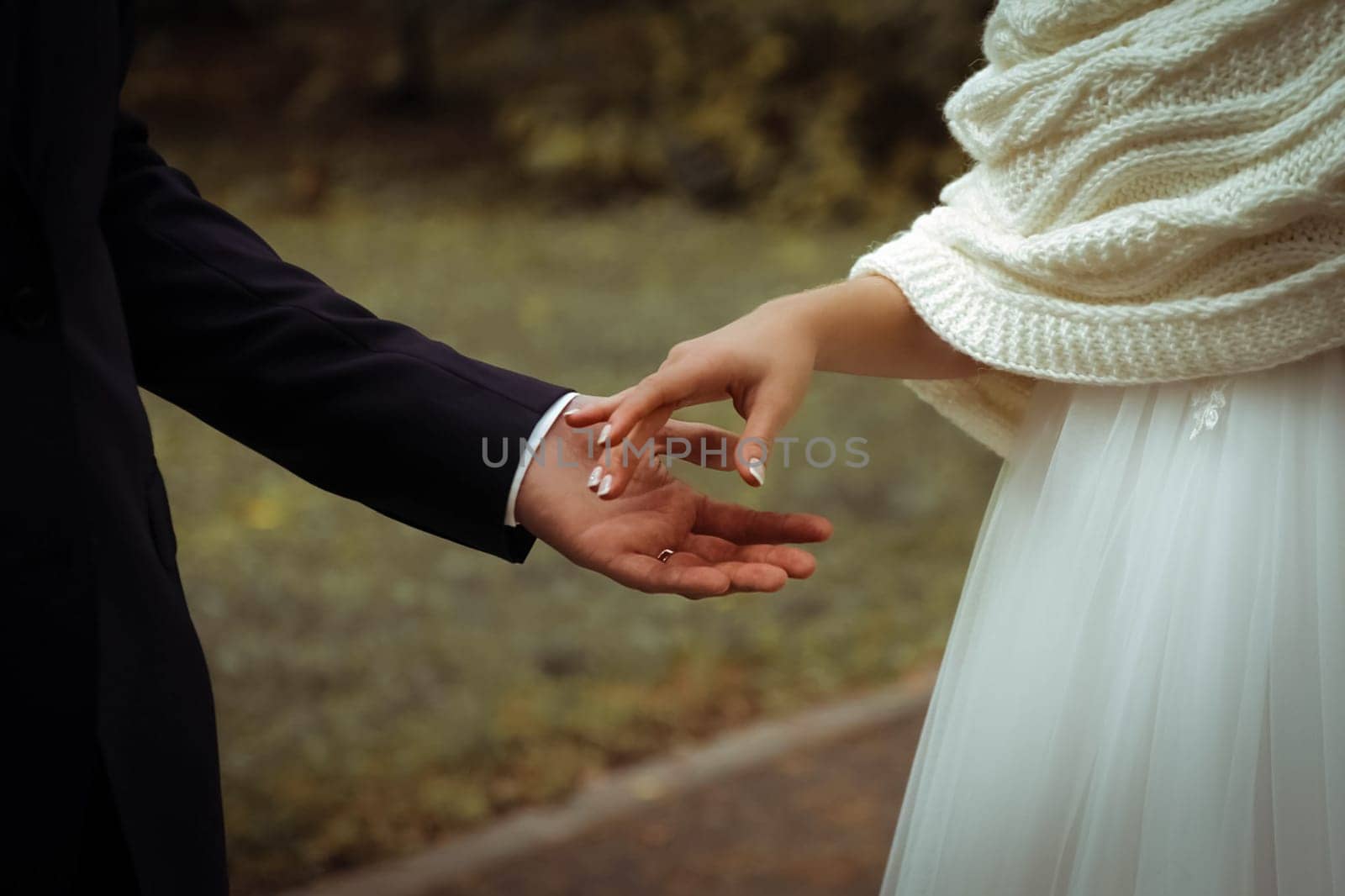 The bride and groom, hold hands. The hand of the bride and groom.