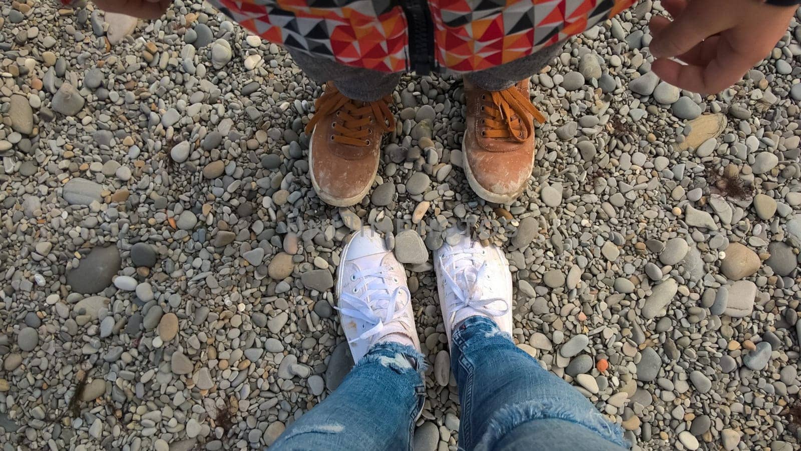 Legs in sneakers opposite each other. Street clothes and shoes.