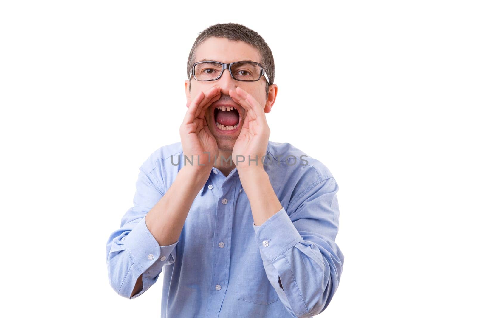 Young business man screaming at you, isolated over white background