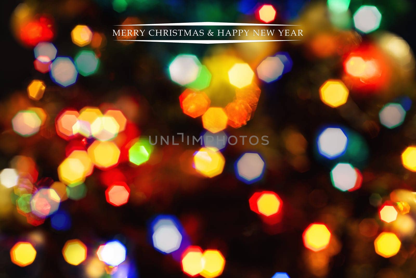 Merry Christmas and Happy New Year greeting card, blurred background of the twinkling lights of the Christmas tree. Greeting card background.
