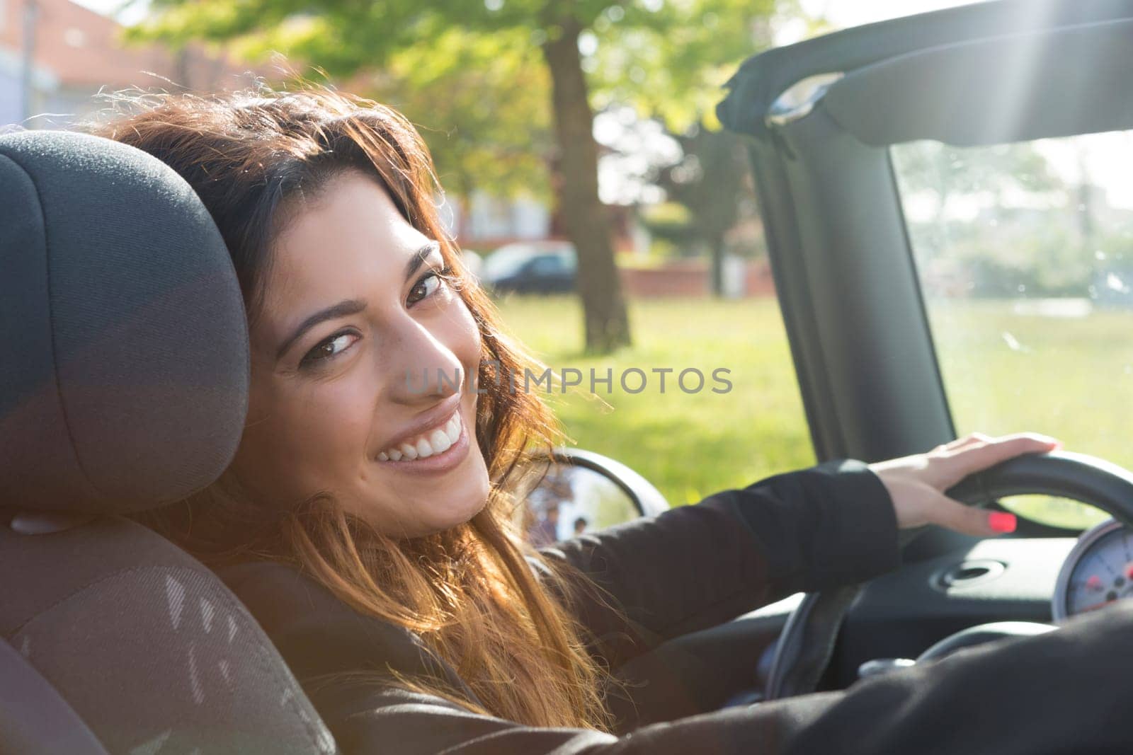 A young successful business woman in a luxurious convertible sports car