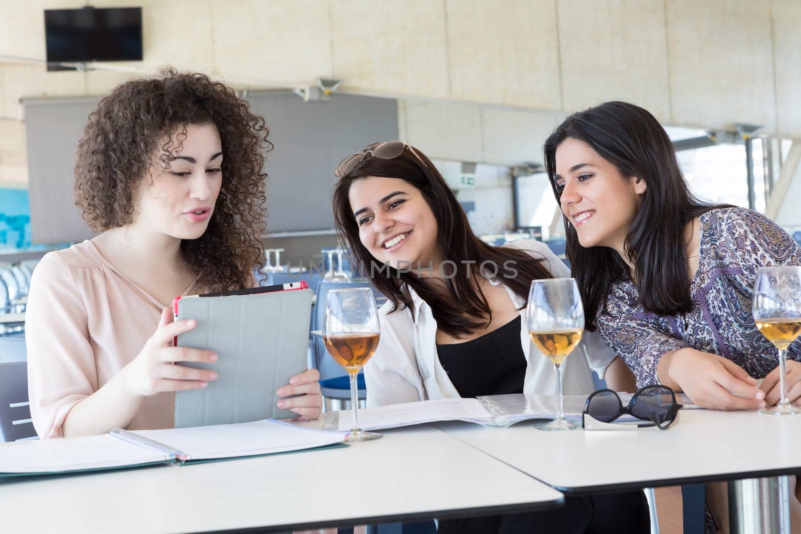Group of happy students preparing their exams or simply relaxing at a bar