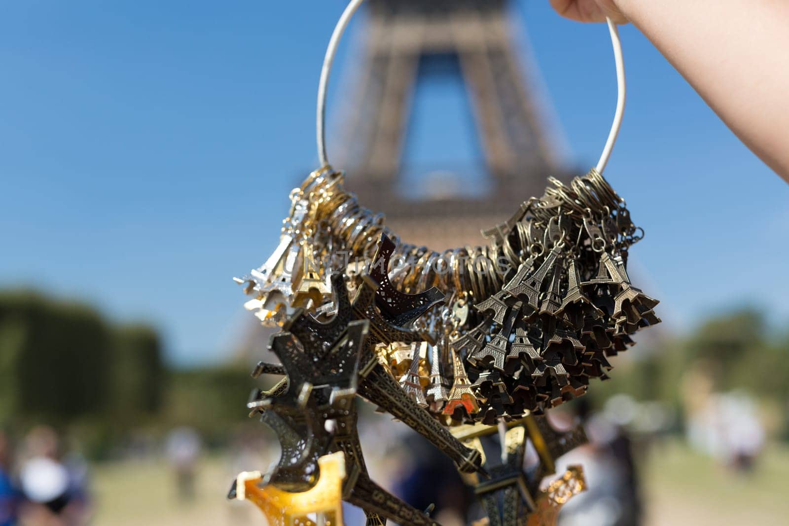 Woman selling small Eiffel Towers in the gardens of the Eiffel Tower, the main attraction in Paris, France
