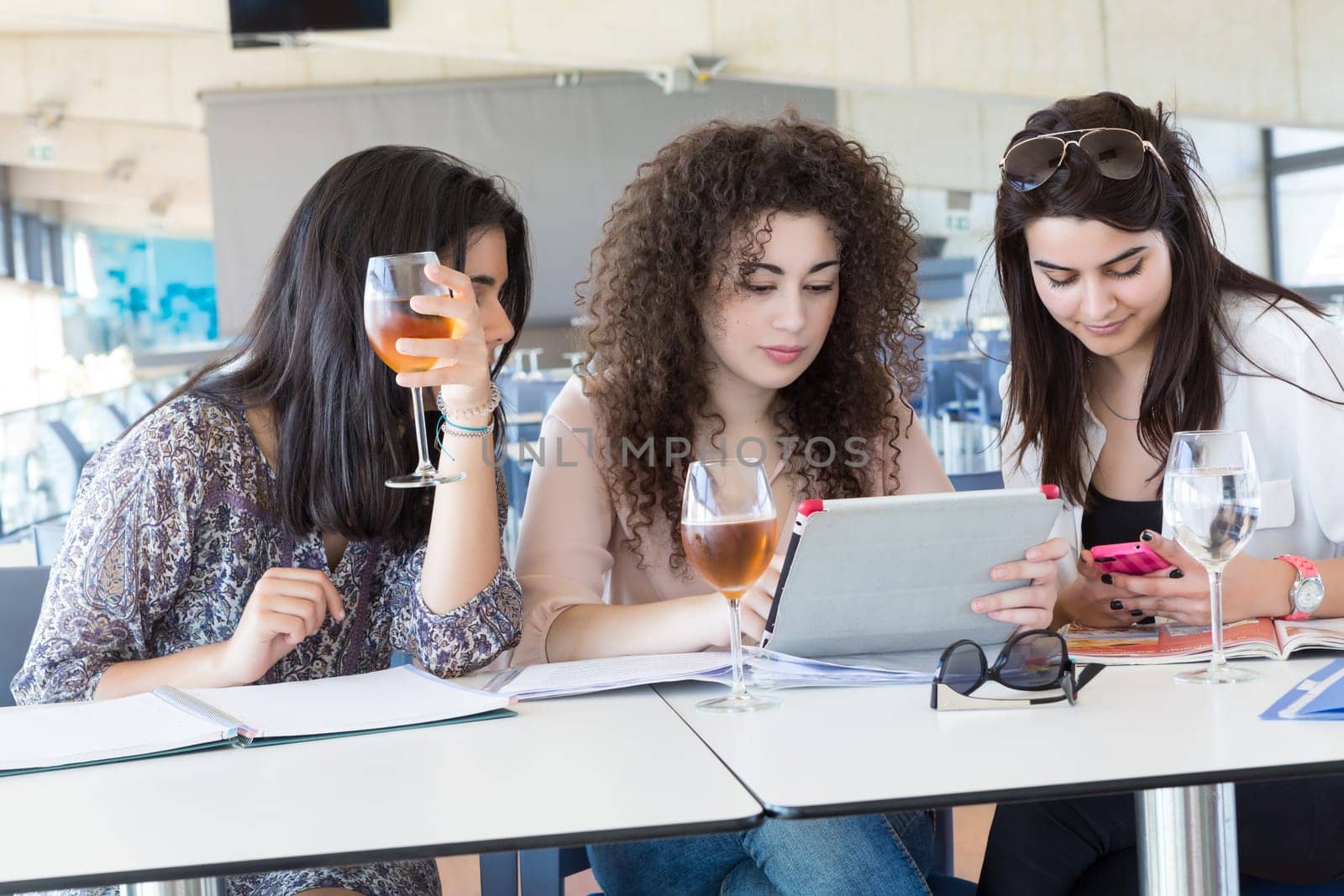 Group of happy students preparing their exams or simply relaxing at a bar