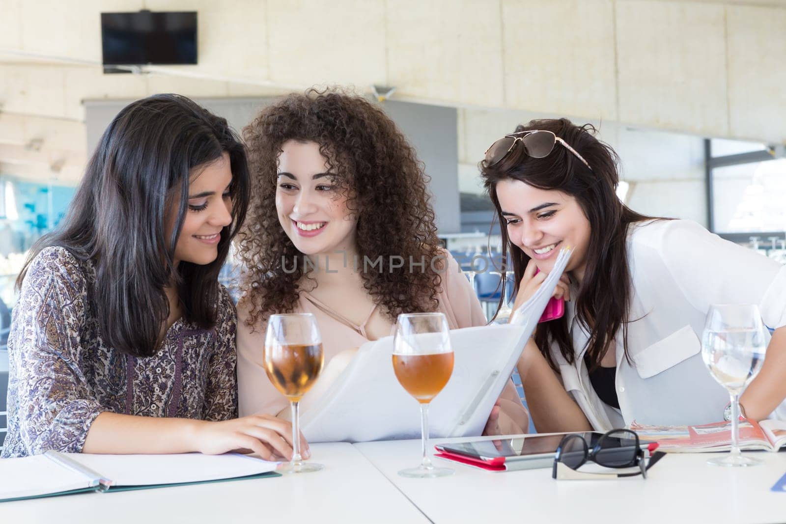 Group of happy students preparing their exams or simply relaxing at a bar