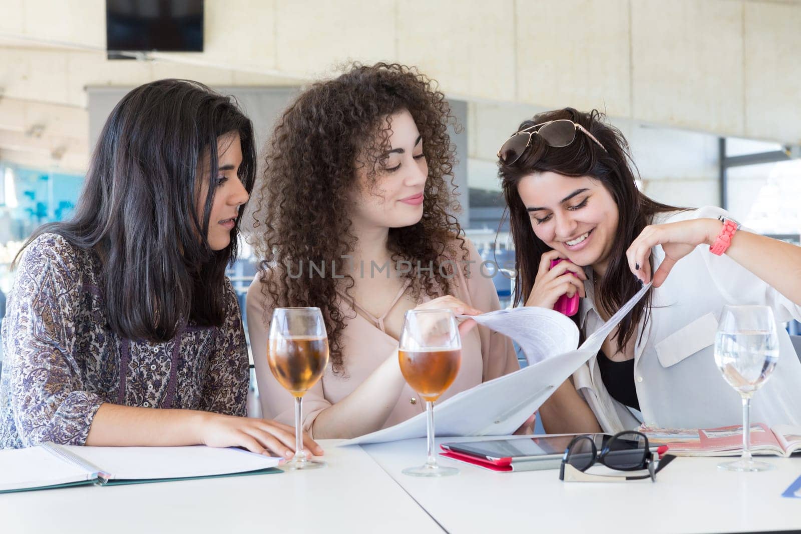 Group of happy students preparing their exams or simply relaxing at a bar