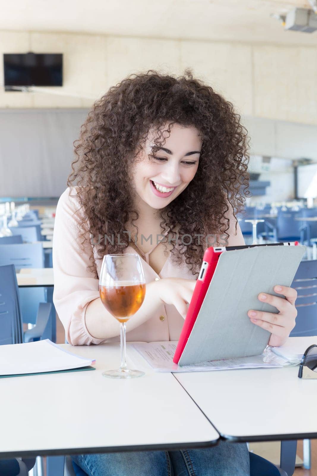 Happy student preparing her exams or simply relaxing at a bar