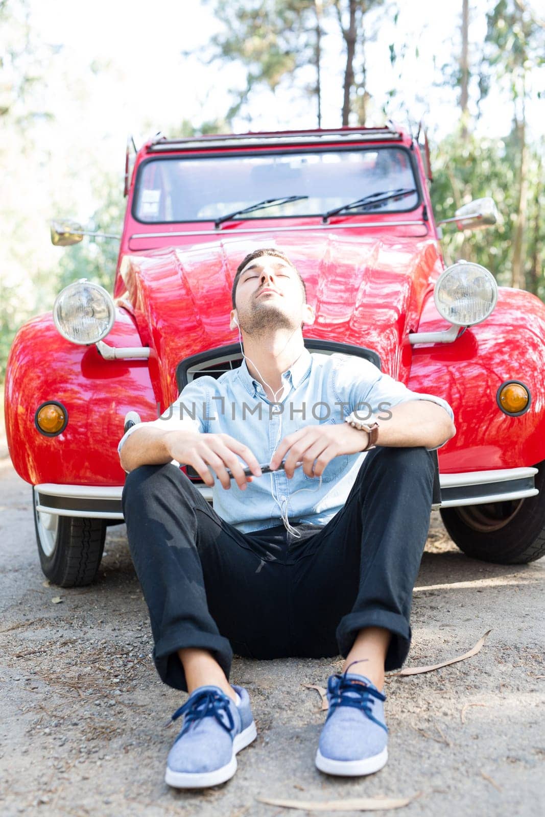 Young man resting at car trip by the countryside