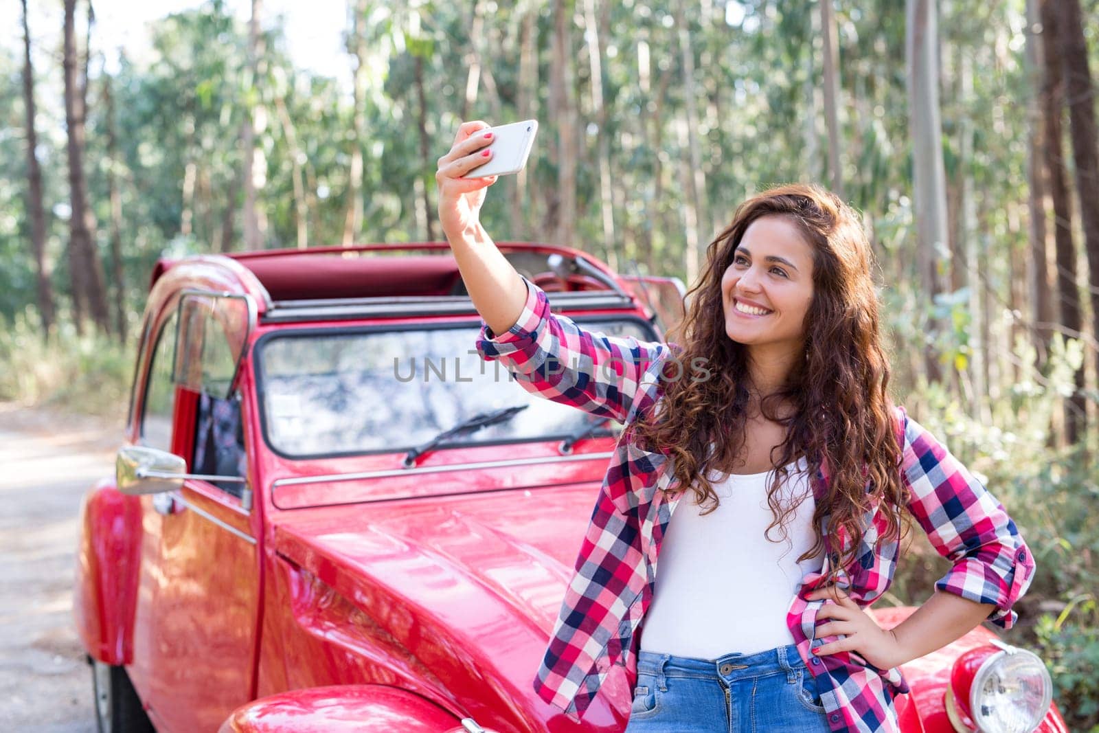 Young woman talking a selfie celebrating the start of a roadtrip