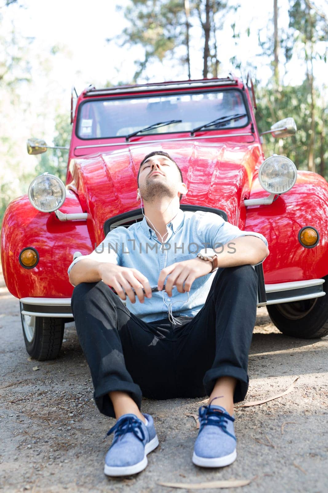 Young man resting at car trip by the countryside